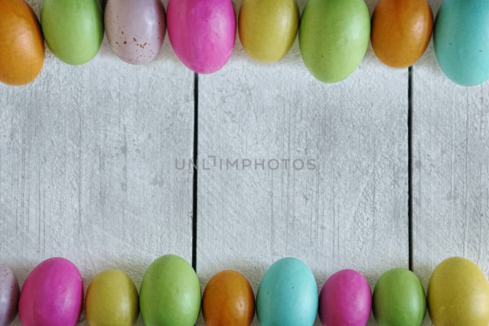 Spring or Easter Themed Background of Old Wood and Colored Eggs Lined Up