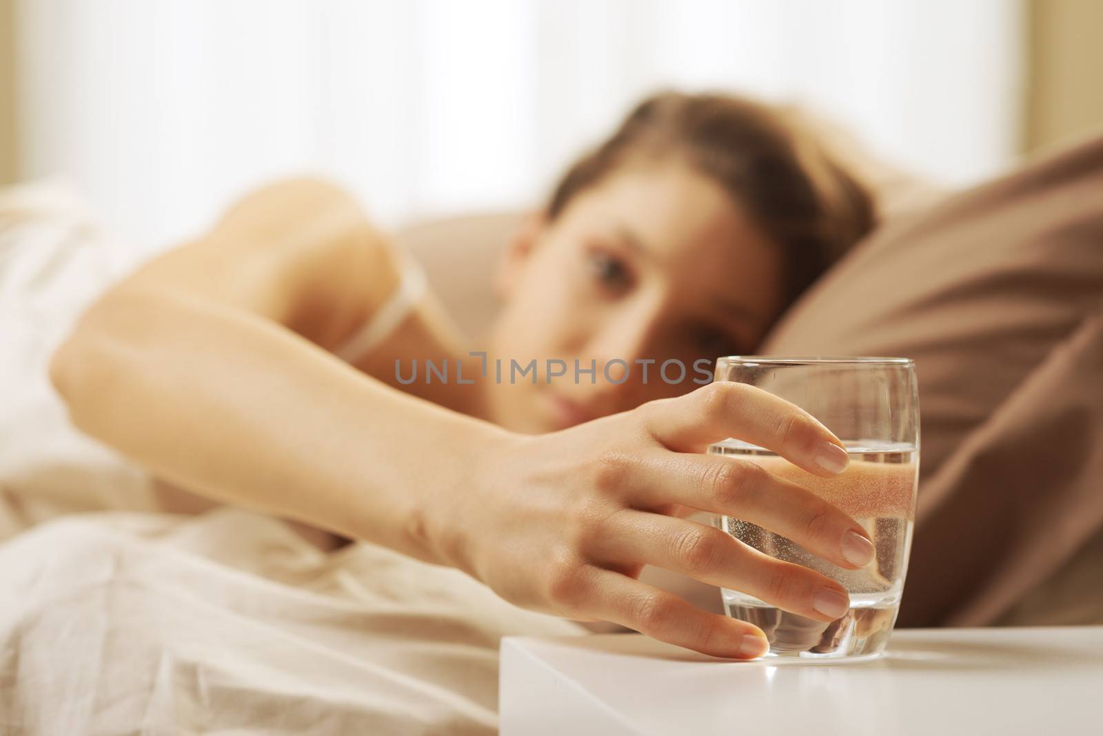 Close up of woman's hand taking a glass of water