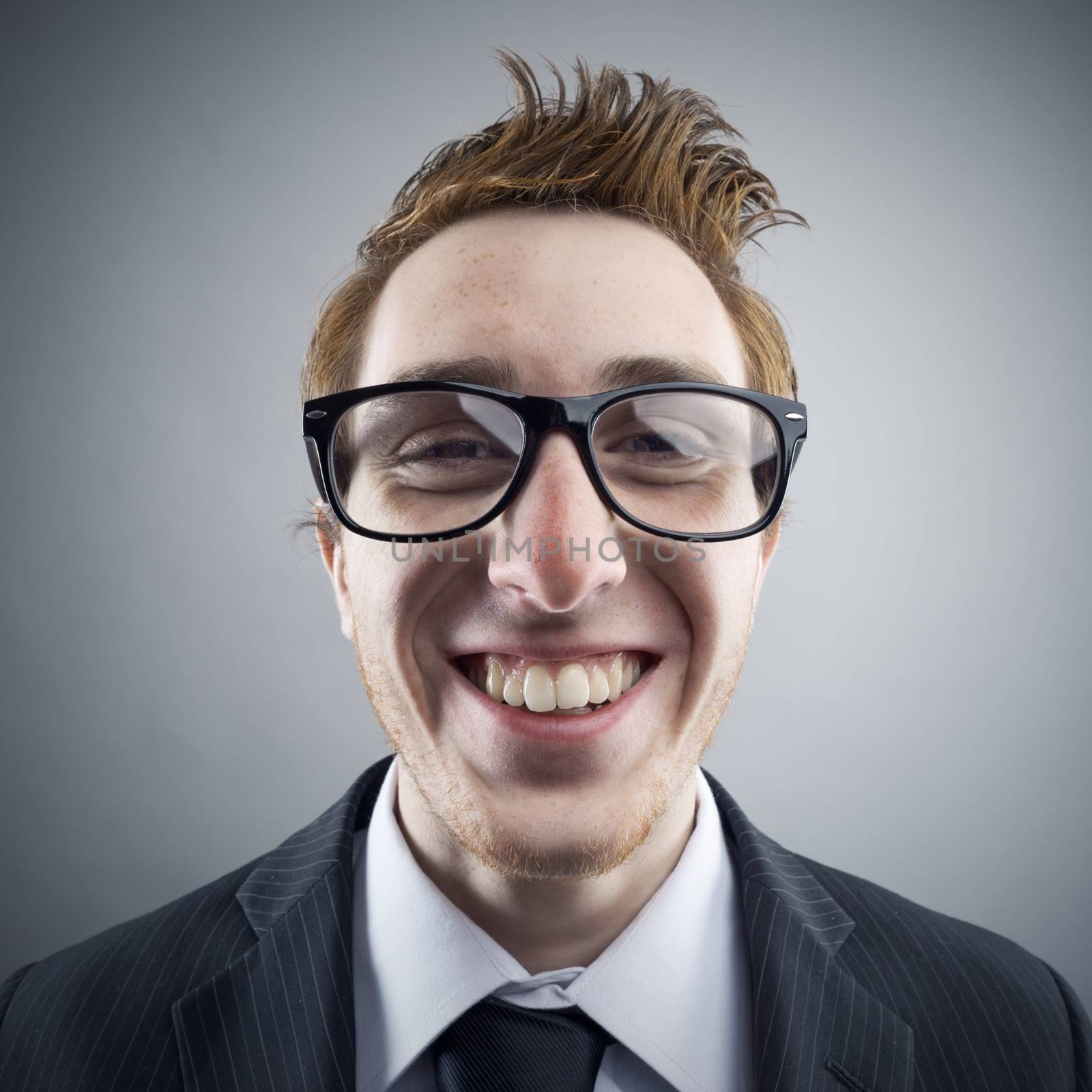 Portrait of young cheerful Nerd businessman smiling