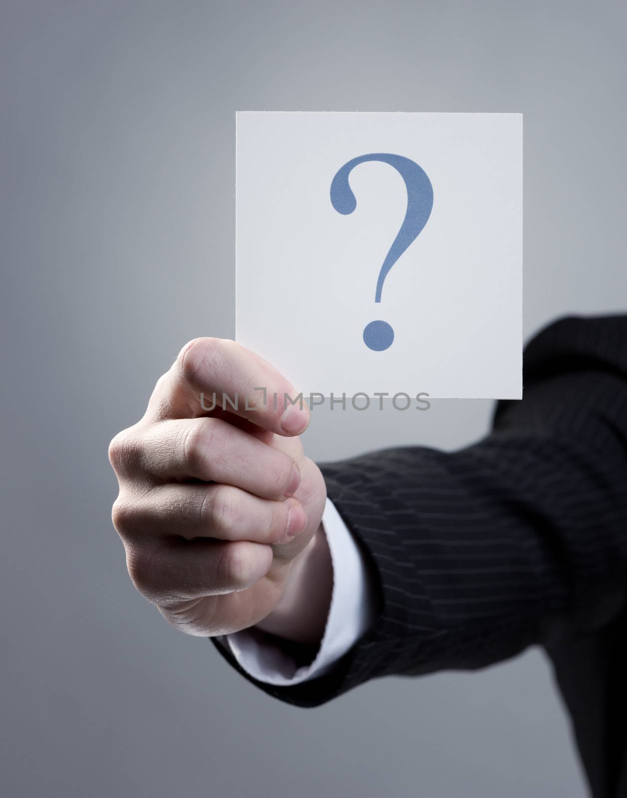 Businessman hand holding a question mark sign, close up