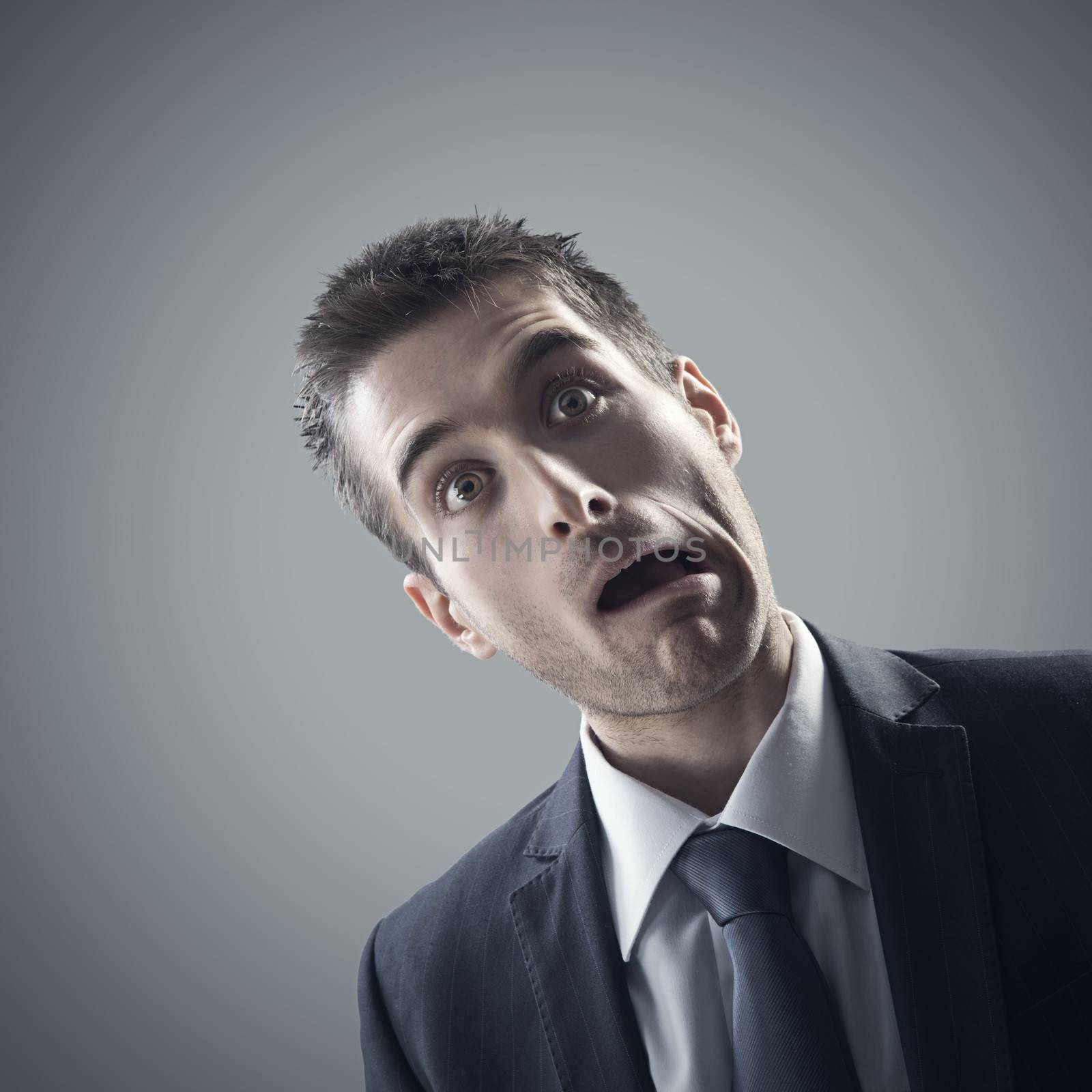 Portrait of stressed business man on grey background