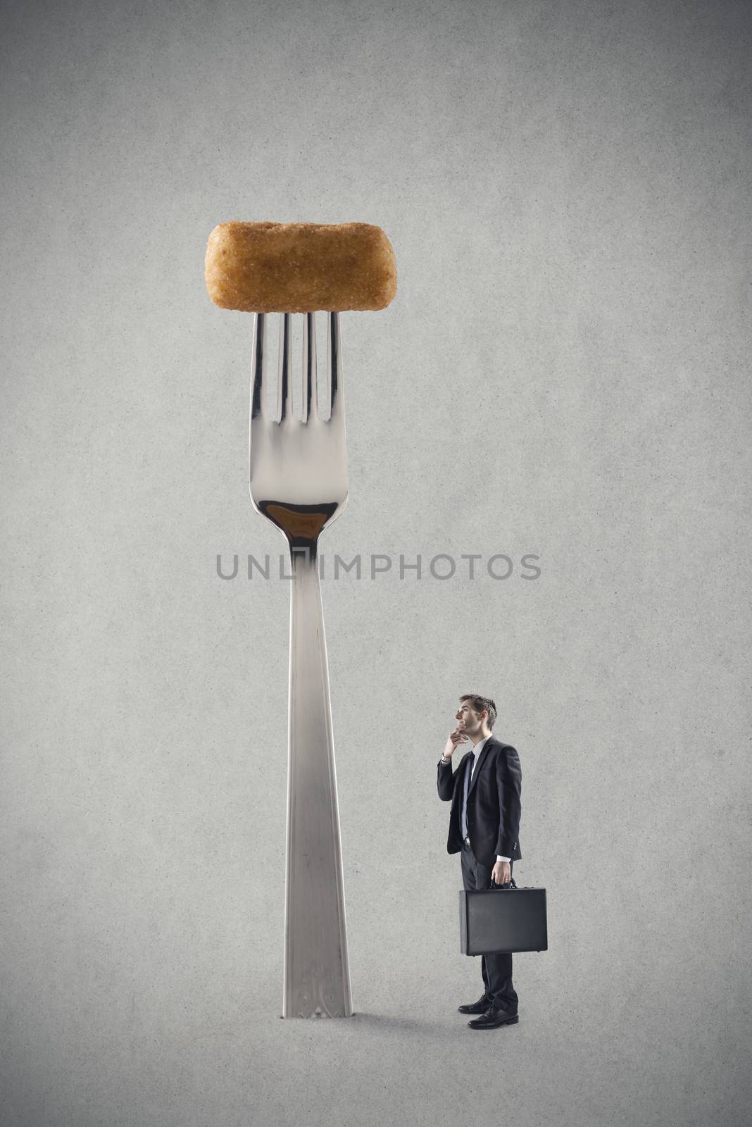 Young businessman thinking in front a big fork with fried potato croquet