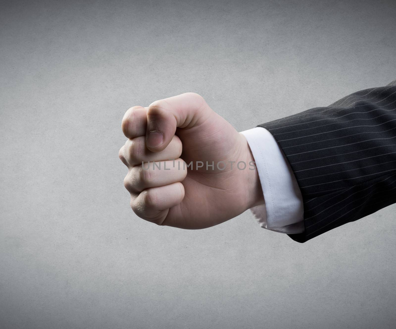 Businessman's fist on gray background