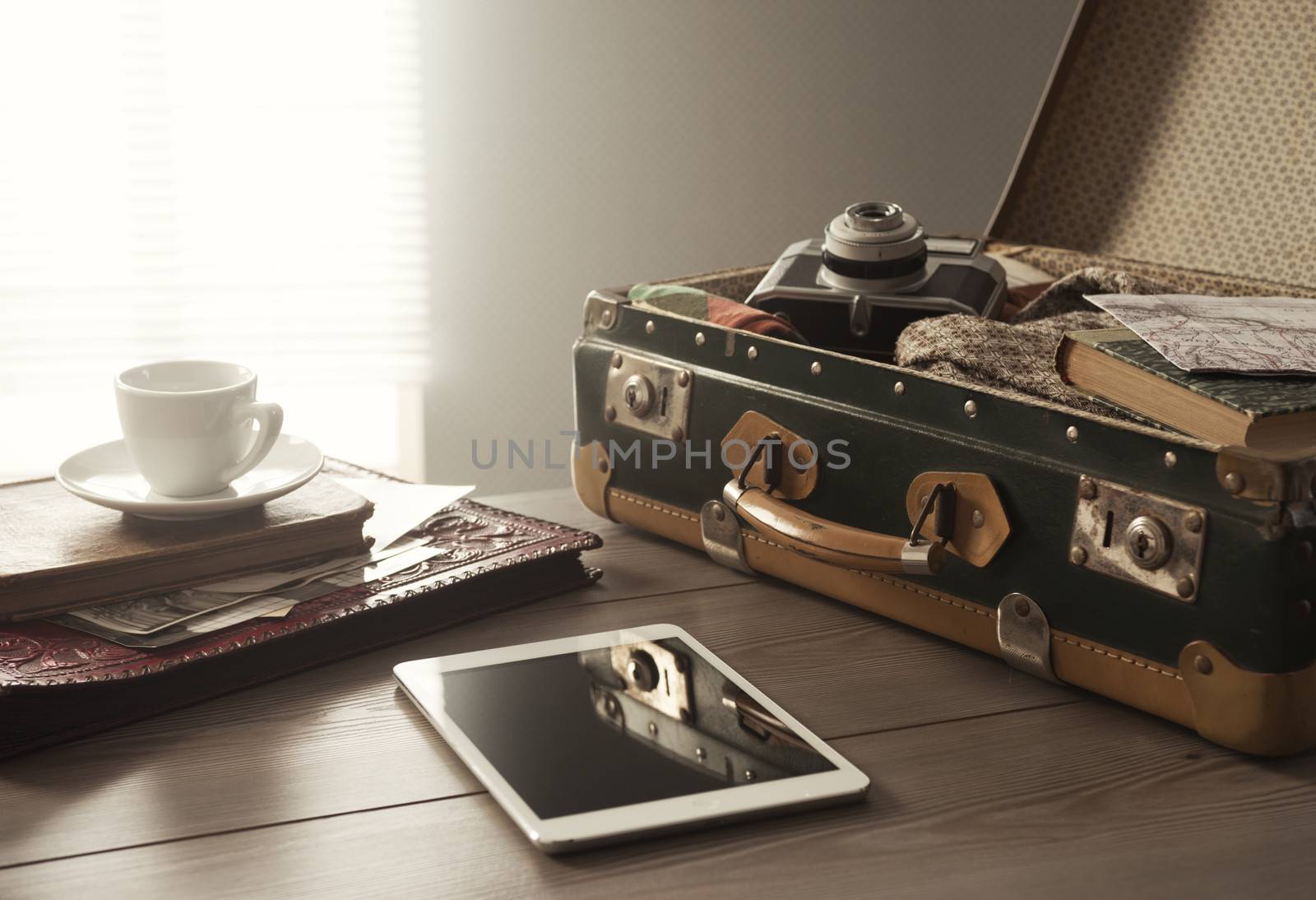 Traveler's suitcase with vintage items, tablet and a cup of coffee.