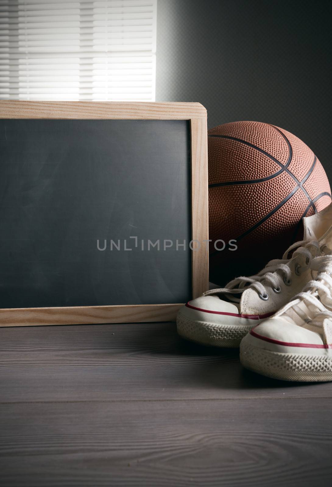 White sneakers with basketball and blank blackboard with copyspace.