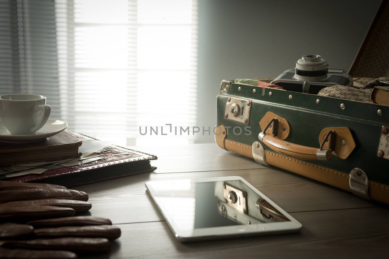 Traveler's suitcase with vintage items, tablet and a cup of coffee.