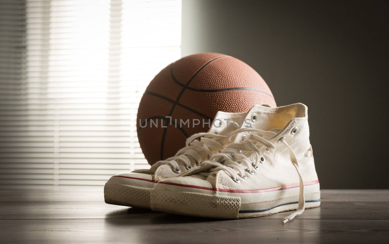 White sneakers with basketball on a wooden table.