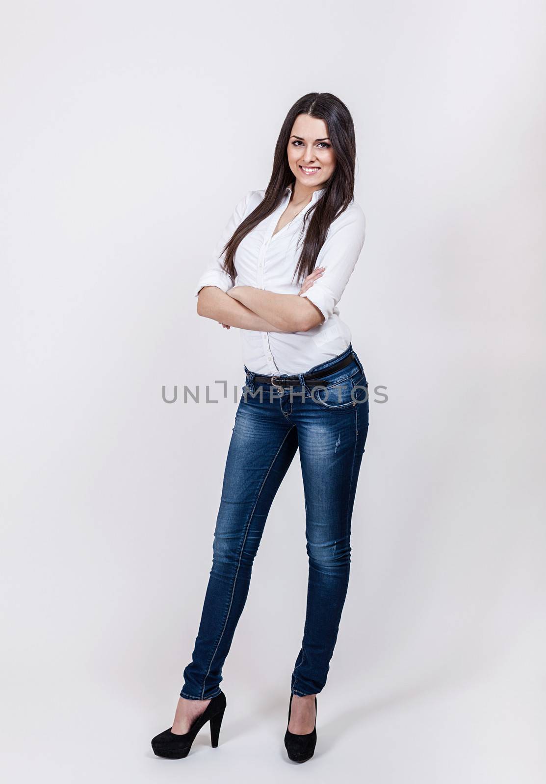 Beautiful young businesswoman standing with hands folded by uros93