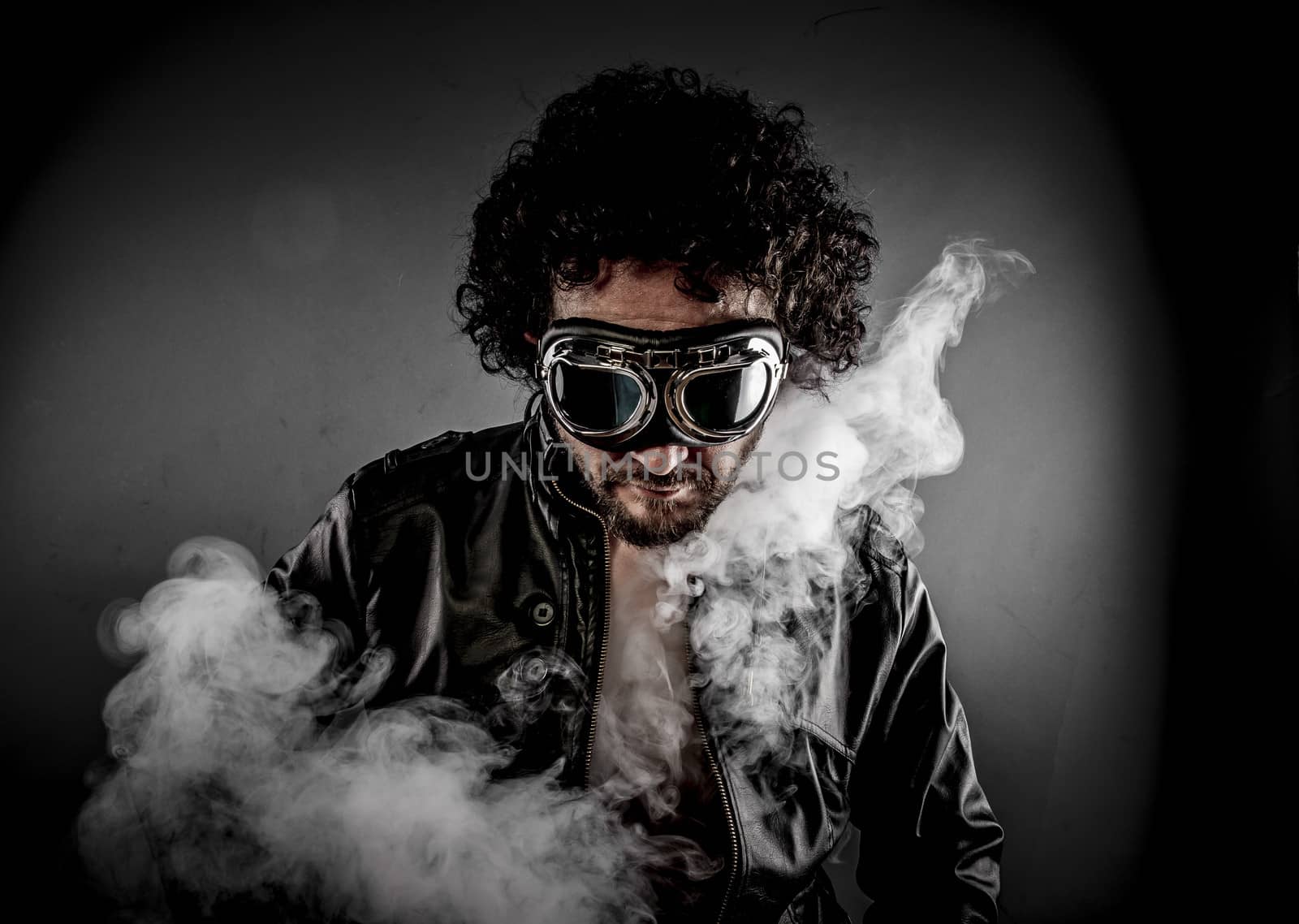 Sensual male biker with sunglasses era dressed Leather jacket, huge smoke over dark background
