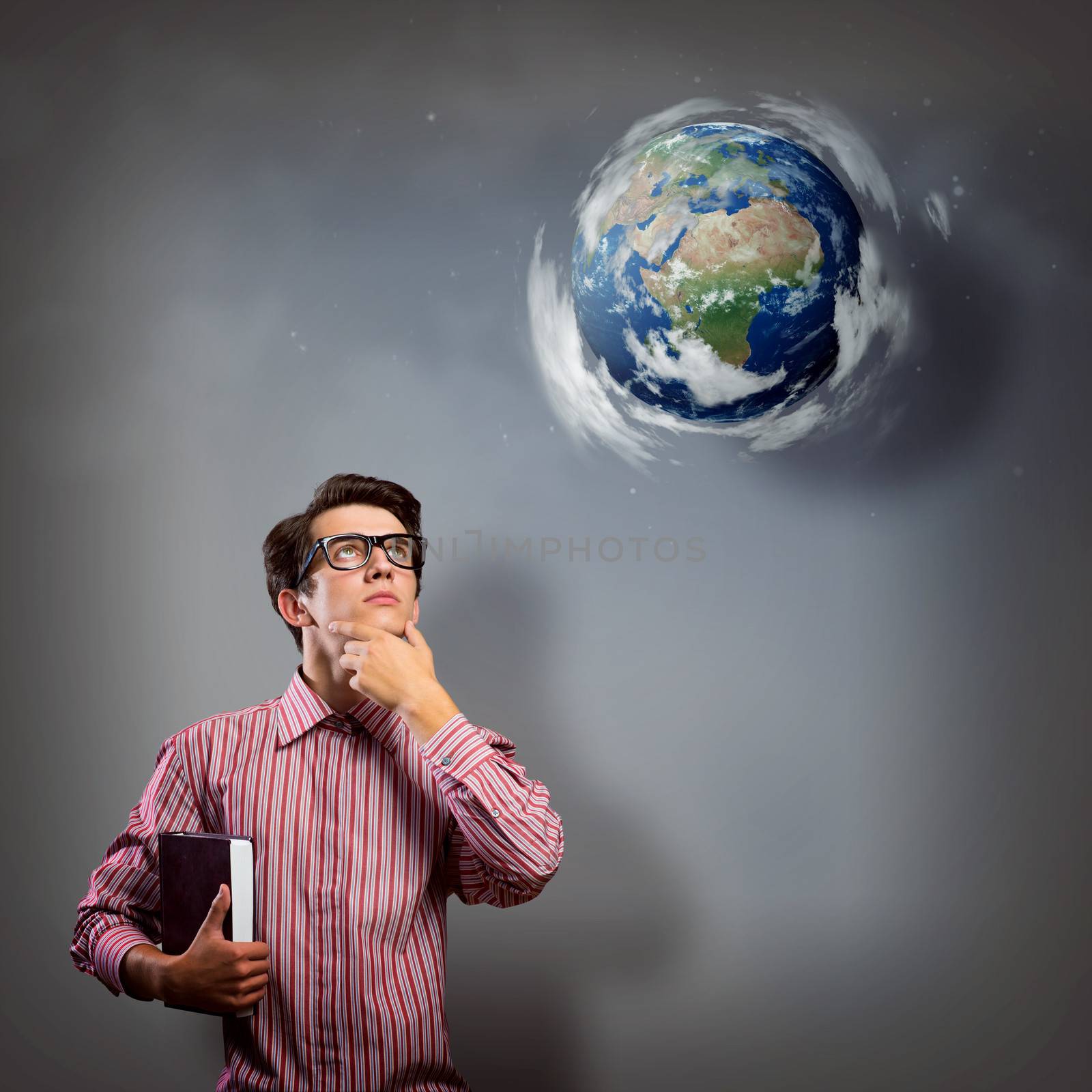 young man with a book thinks. it over planet Earth with clouds. an image of NASA.