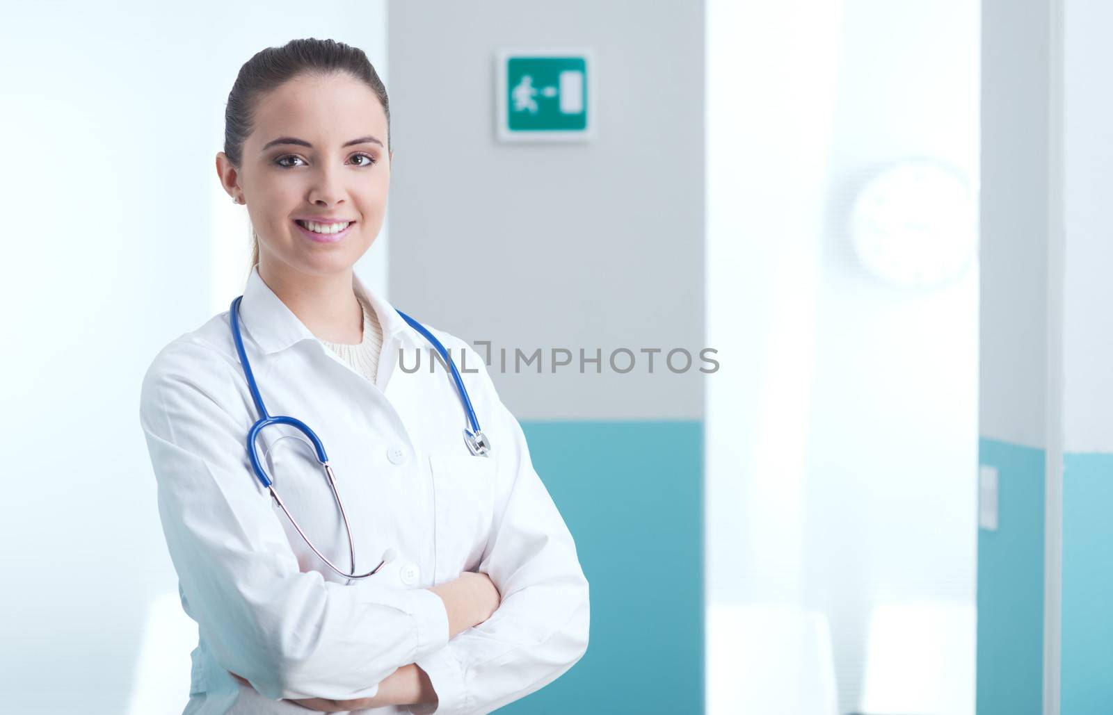 Portrait of a smiling female doctor standing with arms folded 