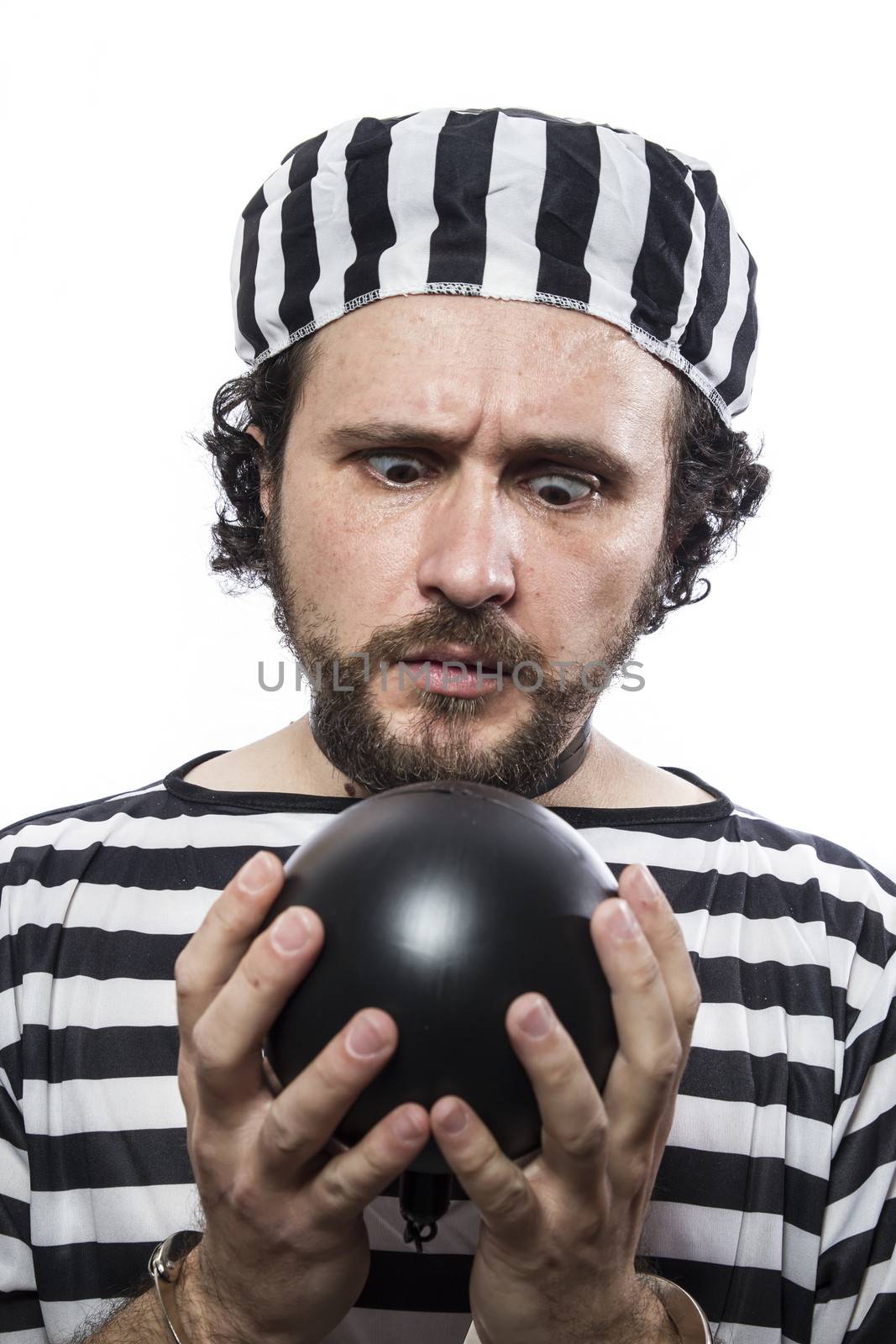 Funny man prisoner criminal with chain ball and handcuffs in studio isolated on white background