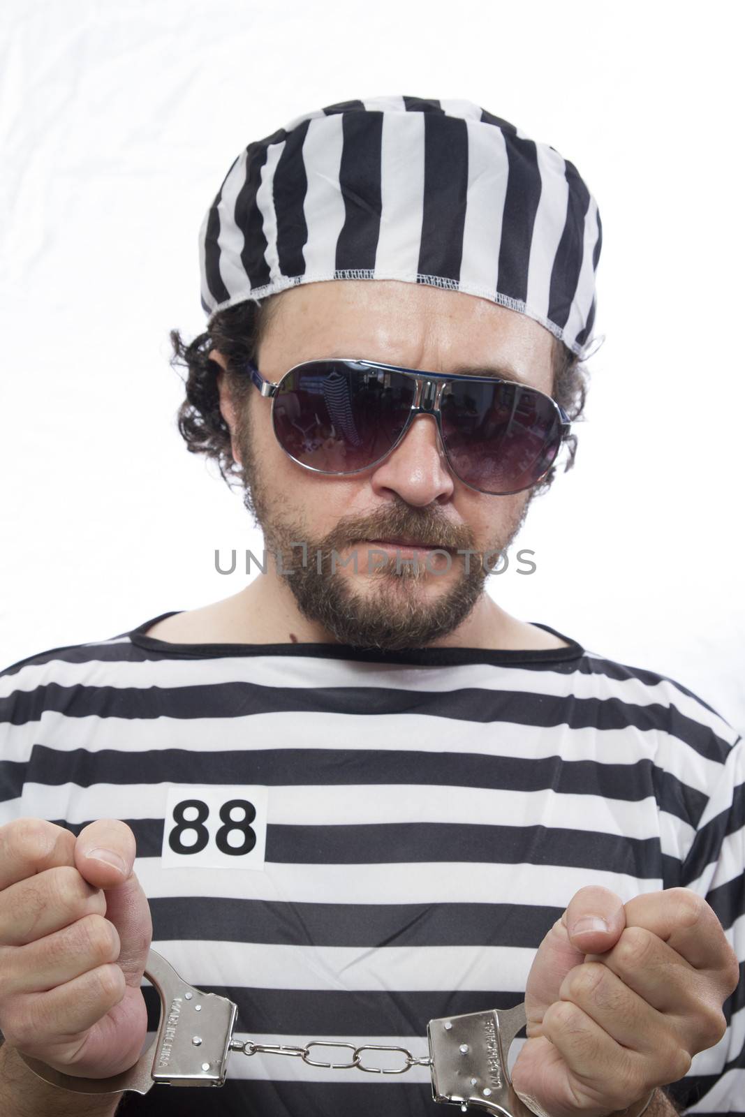 Locked, Desperate, portrait of a man prisoner in prison garb, over white background