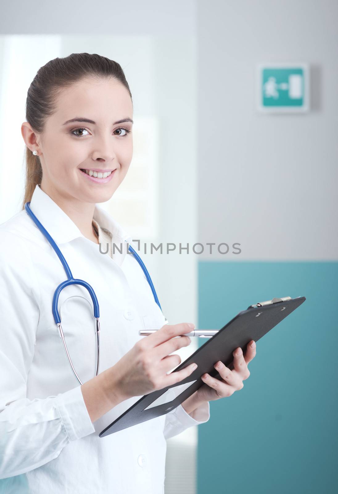 Young woman doctor or pharmacist in office with clipboard