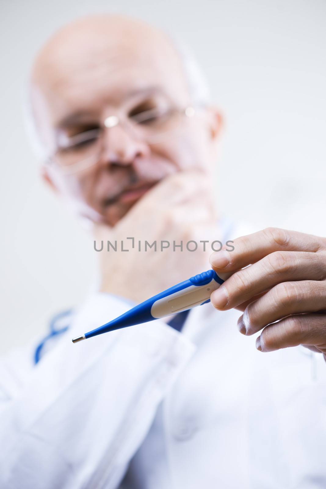 Senior male doctor measuring temperature with a thermometer.