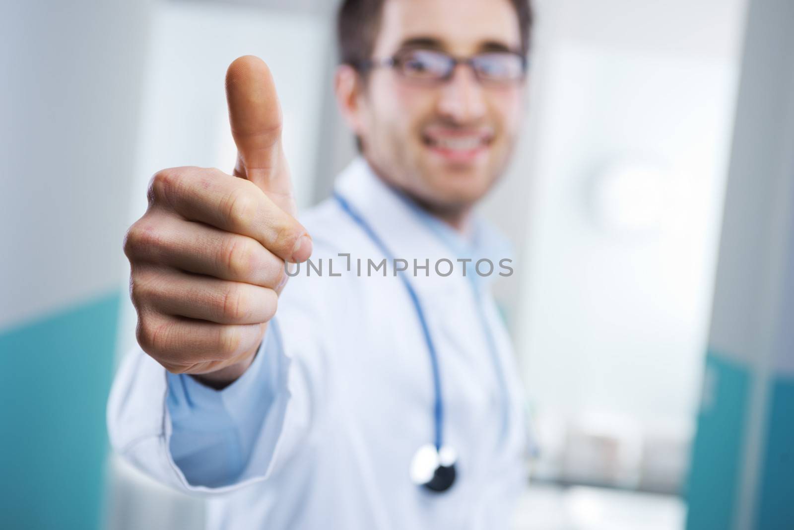 Young doctor expressing positivity and smiling with thumb up