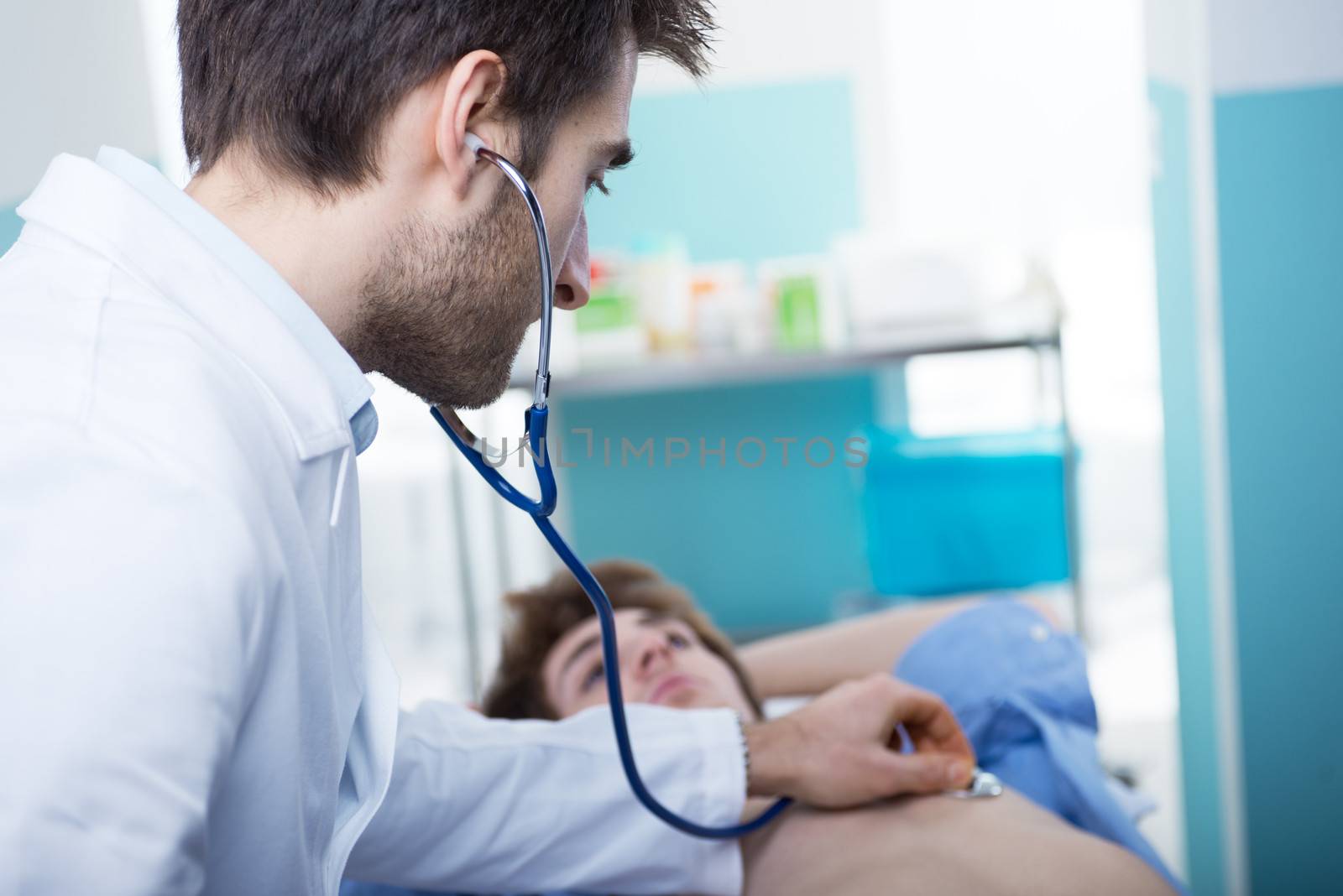 Doctor examining patient's heartbeat  with a stethoscope
