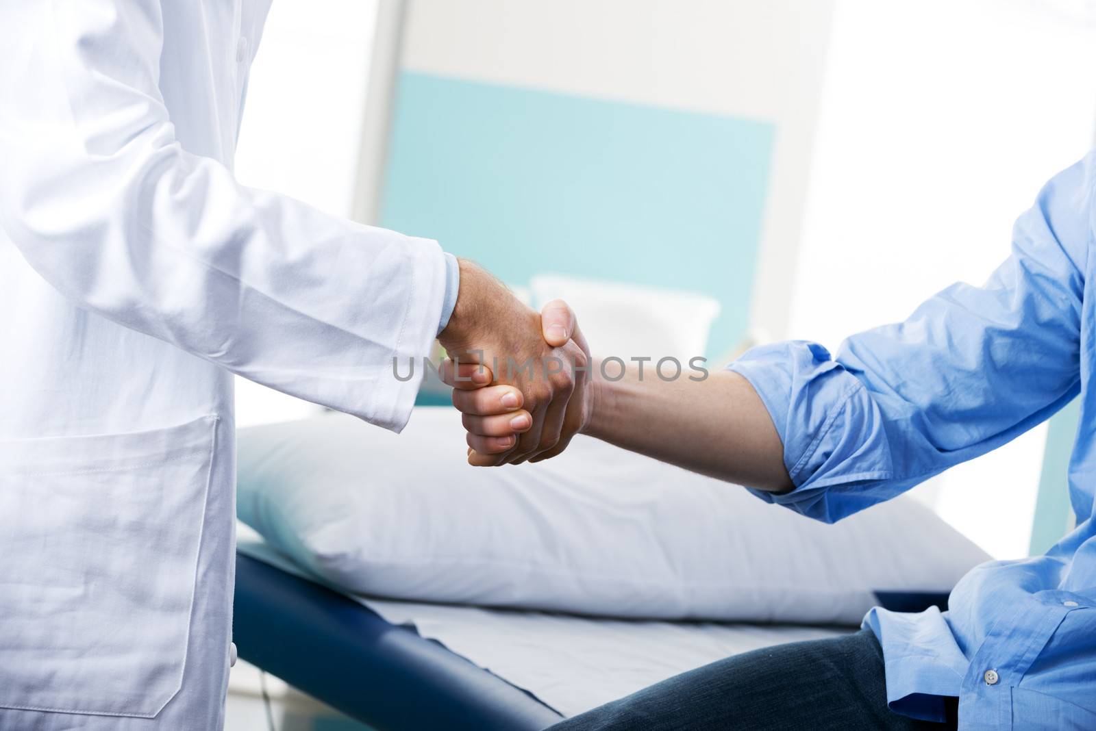 Doctor and patient handshake close-up at the clinic.