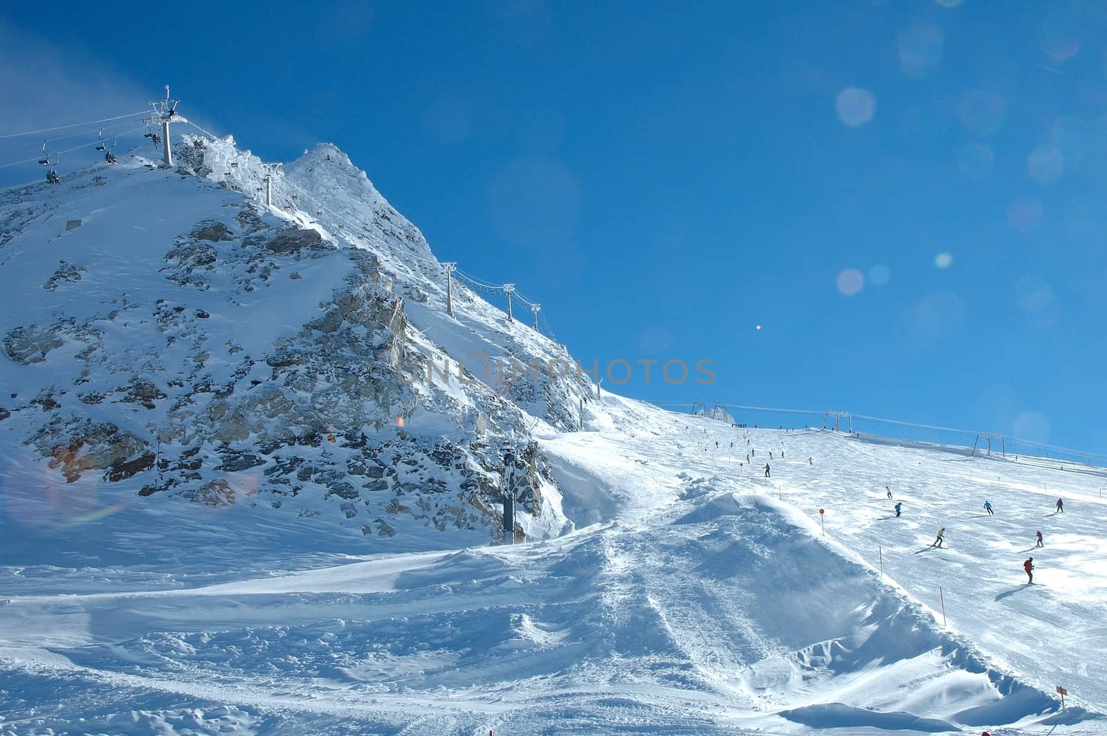 Ski slope, lift and skiers on Hintertux glacier in Alps nearby Zillertal valley in Austria