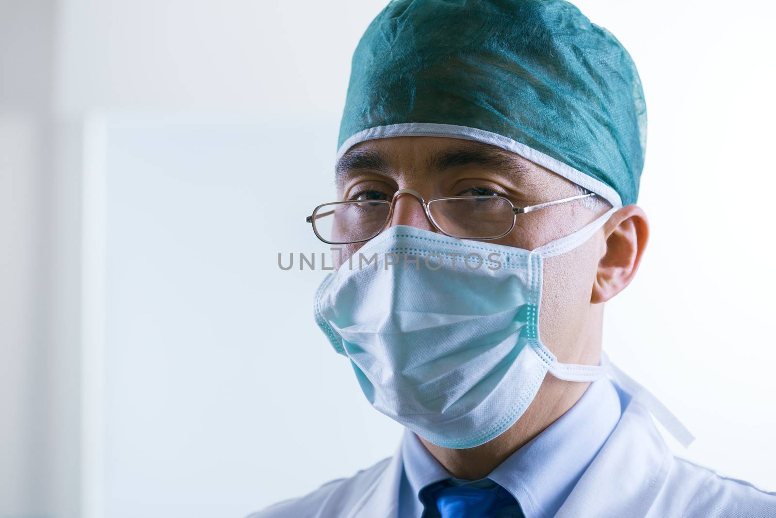 Senior professional surgeon with surgical mask and cap.