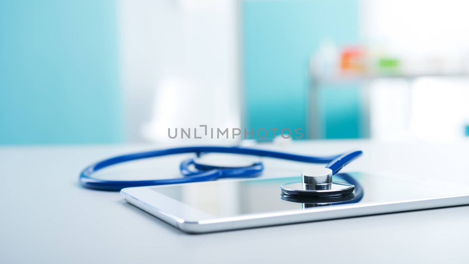 Medical equipment: blue stethoscope and a digital tablet.