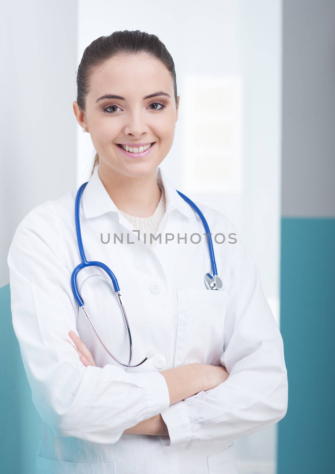 Portrait of a smiling female doctor standing with arms folded 