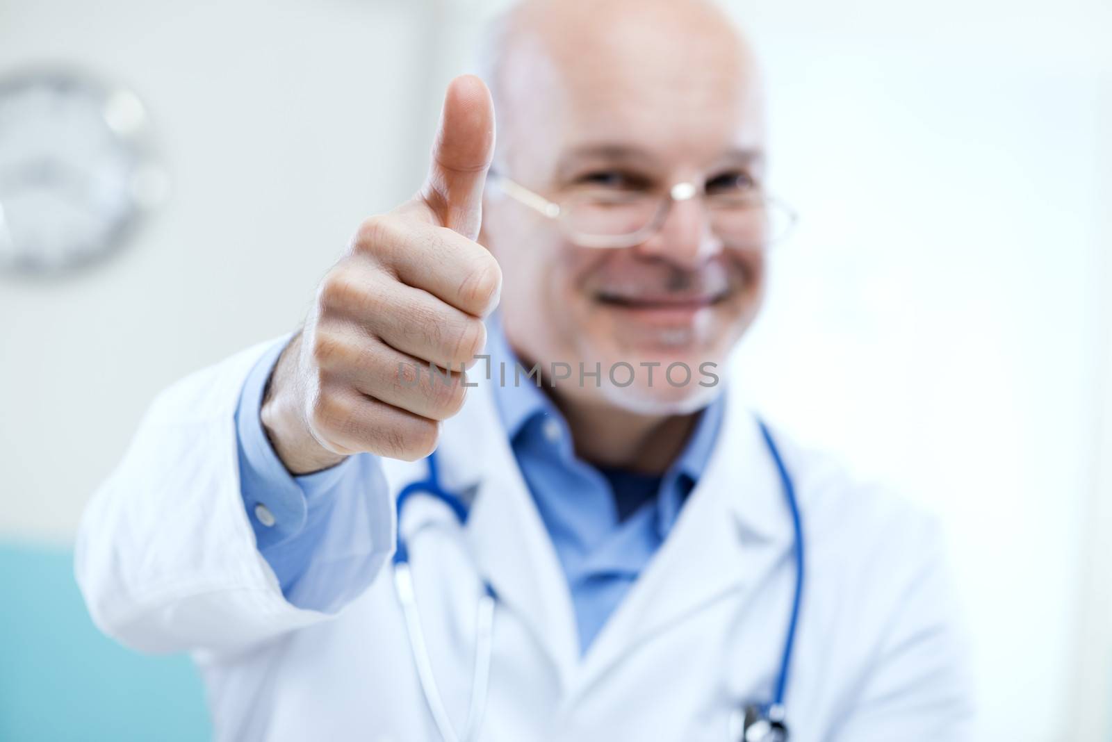 Friendly smiling doctor with thumbs up at the hospital.