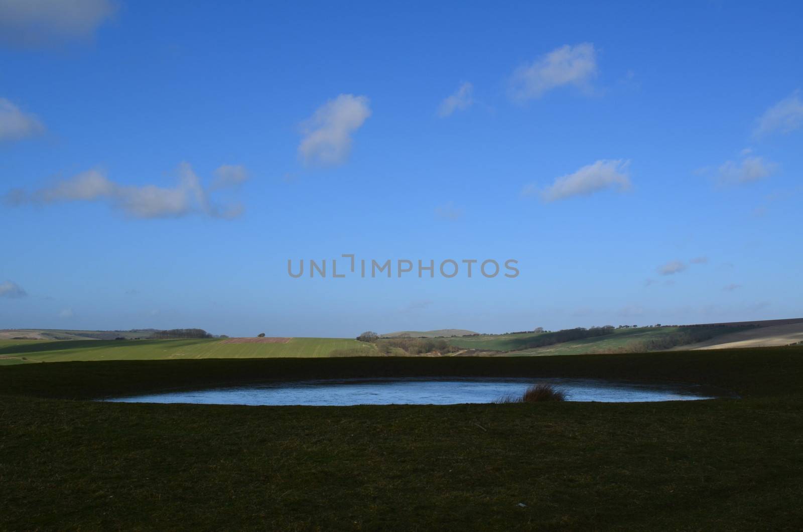 Countryside dew pond on the Sussex South Downs.Manmade livestock water hole.