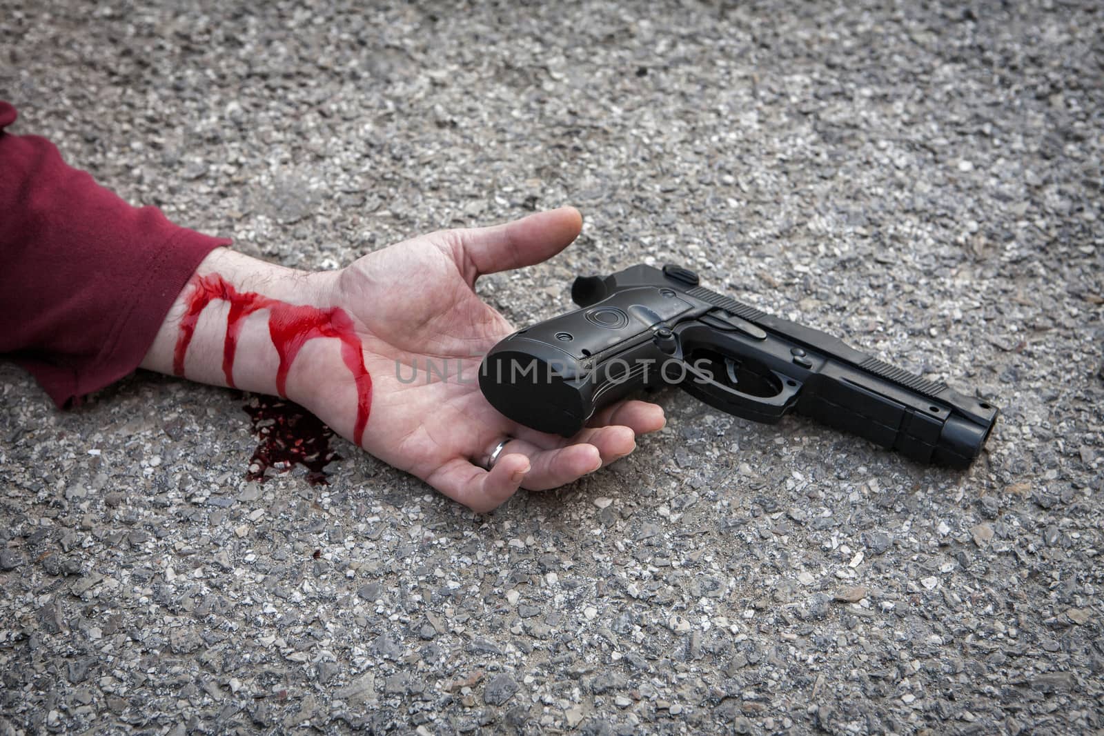 man's hand lying on the floor after suicide with a gun 