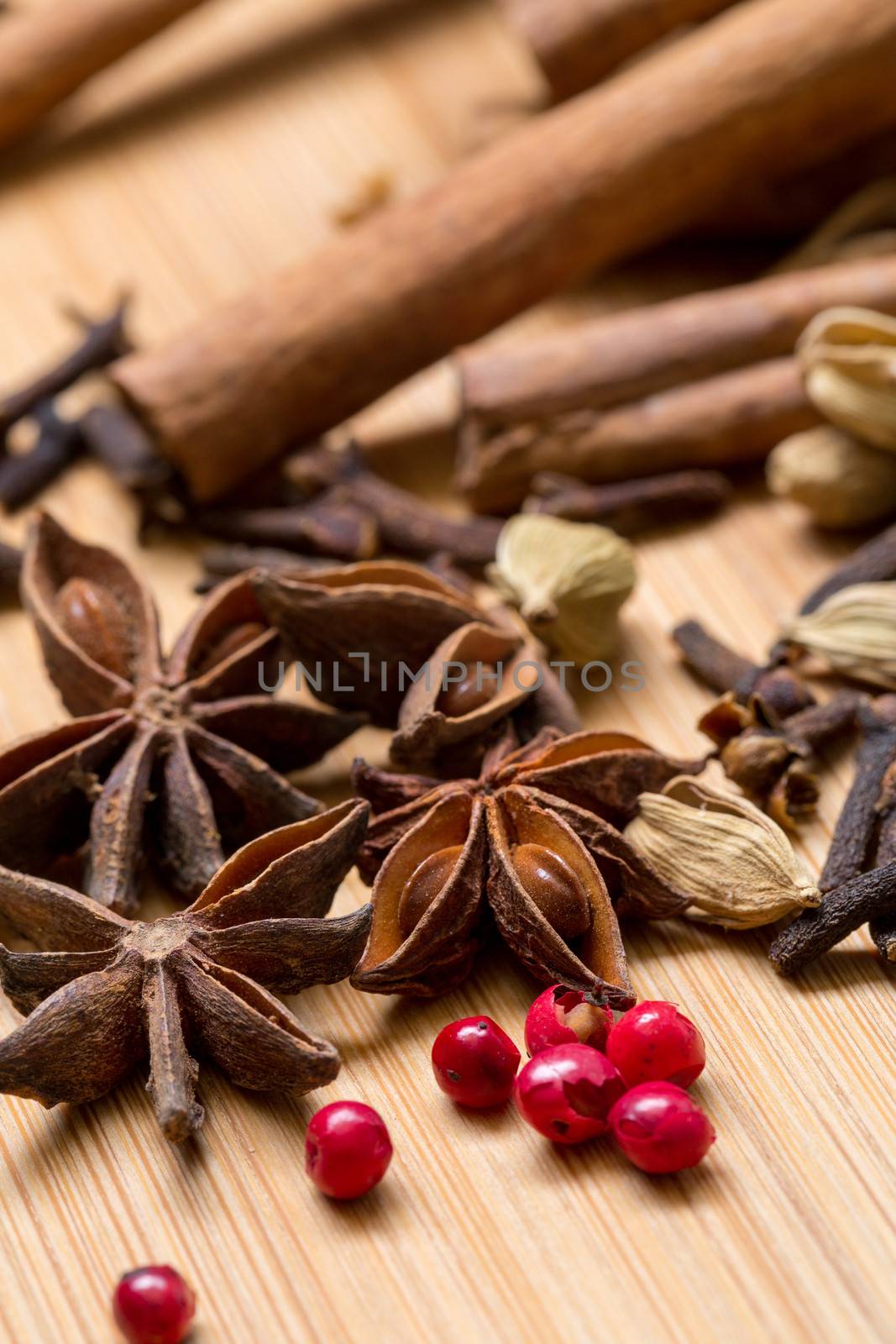 Dry multicolored spice closeup on wooden background
