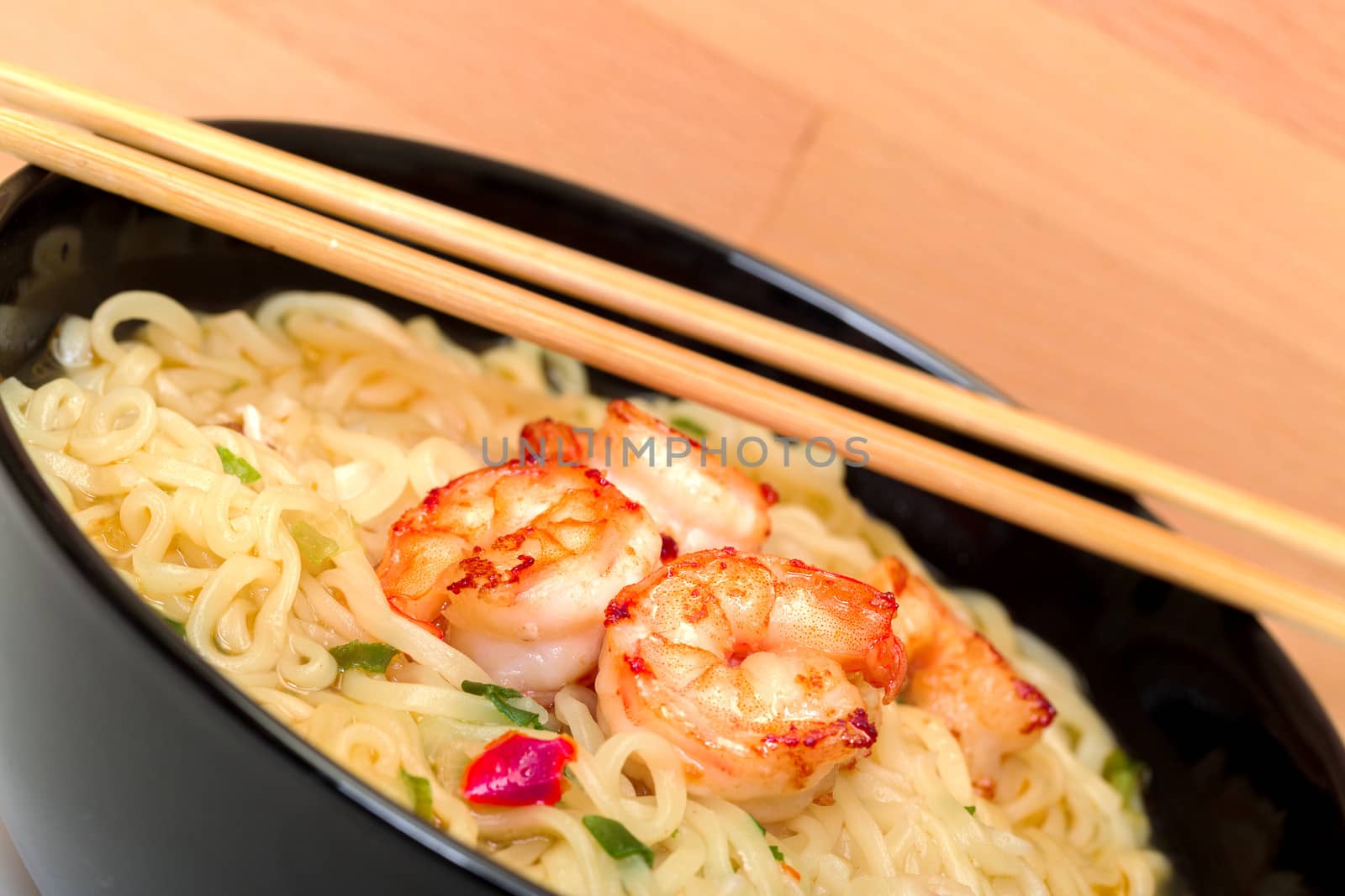 Shrimp and noodle soup bowl with chopsticks closeup