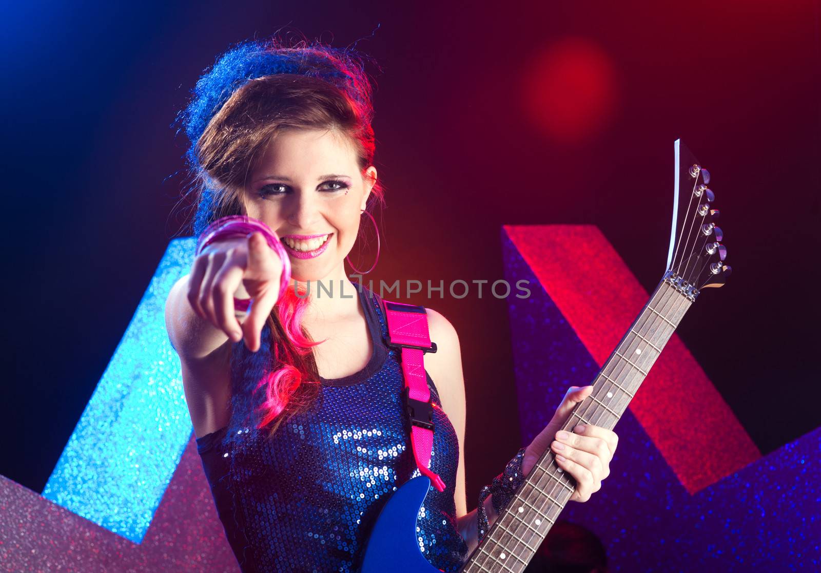 Young attractive pop star girl pointing at camera and smiling.
