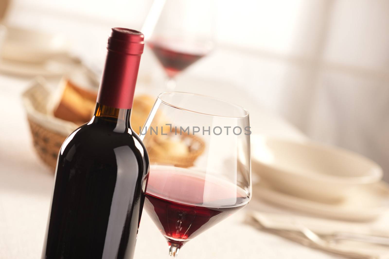 Red wine glass and bottle still life at restaurant.