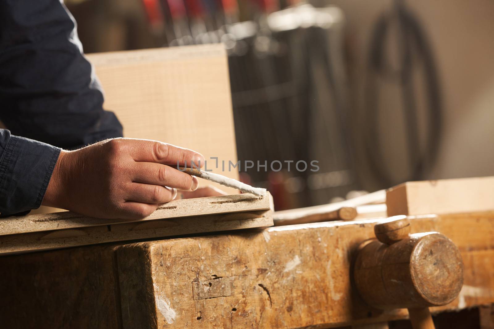 Professional carpenter applying glue on a wooden surface with brush.