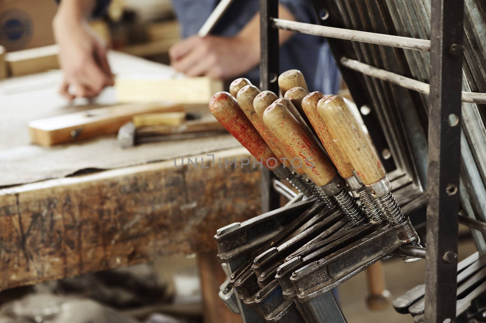 A set of wire saws with carpenter working on background.