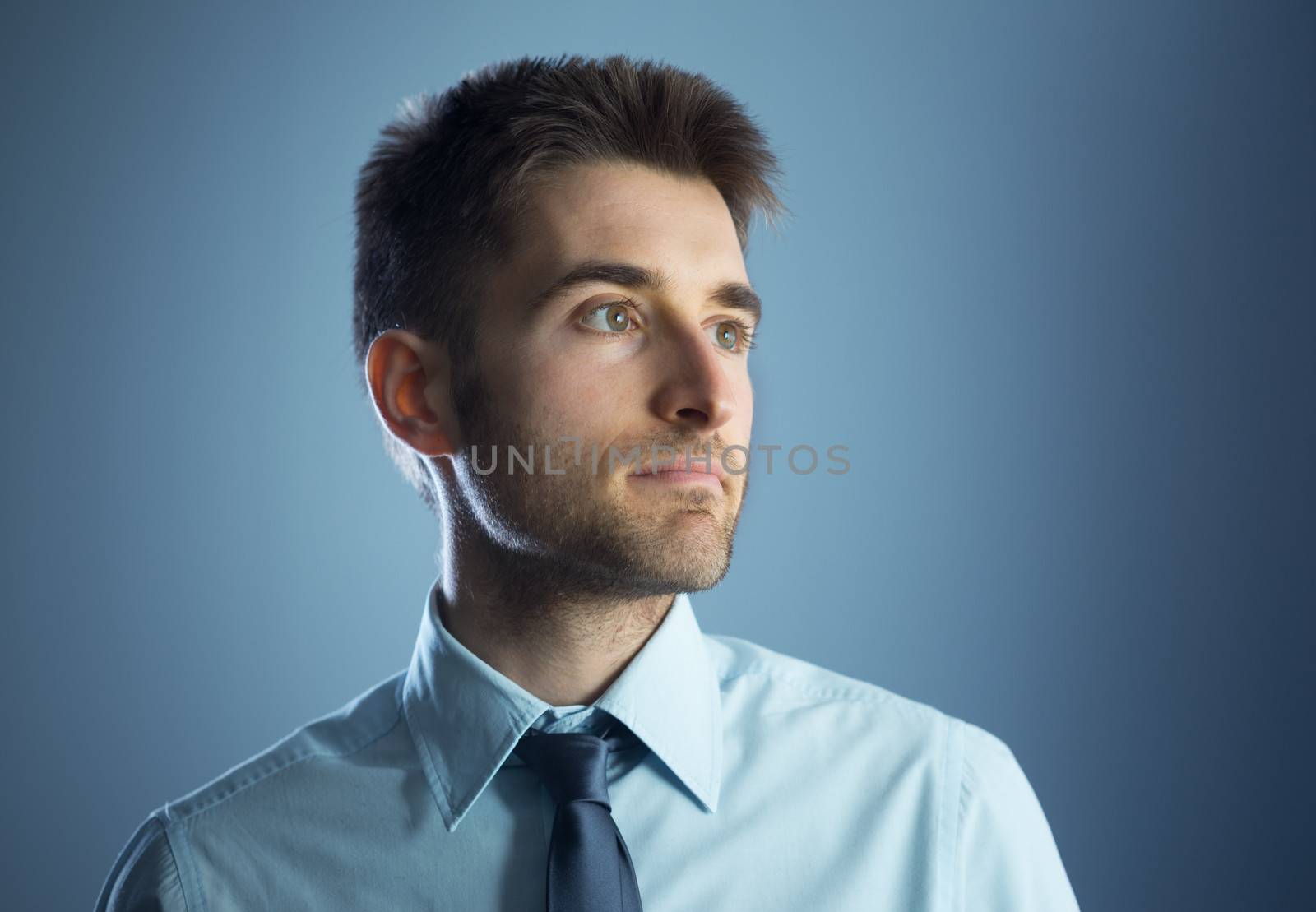 Confident young businessman looking away and thinking.