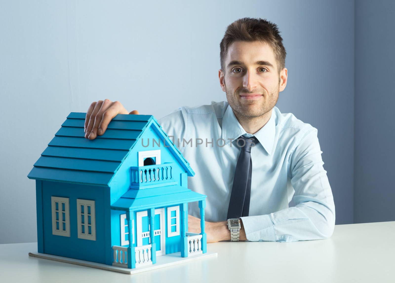 Real estate agent with model house by stokkete
