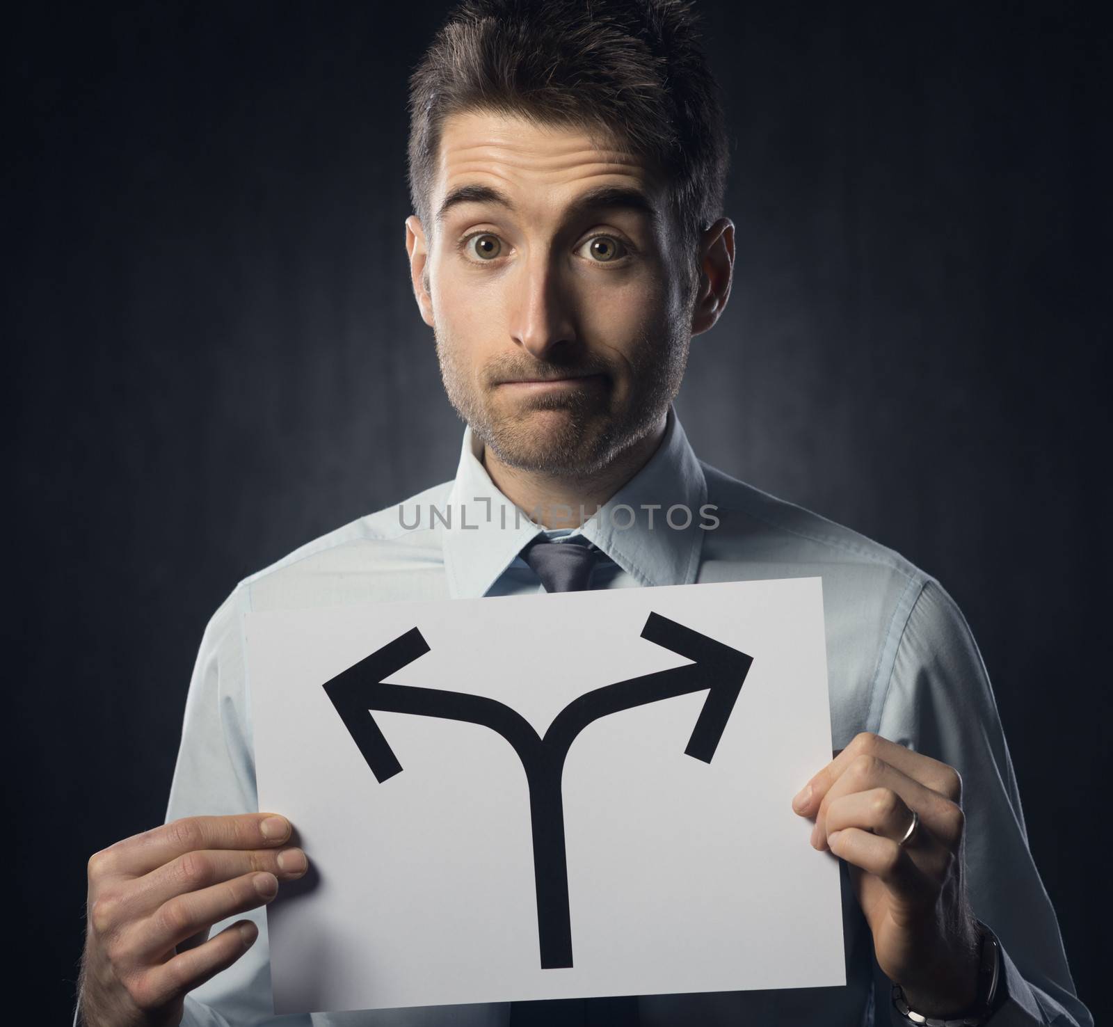 Man holding a sign with directions and pensive expression.