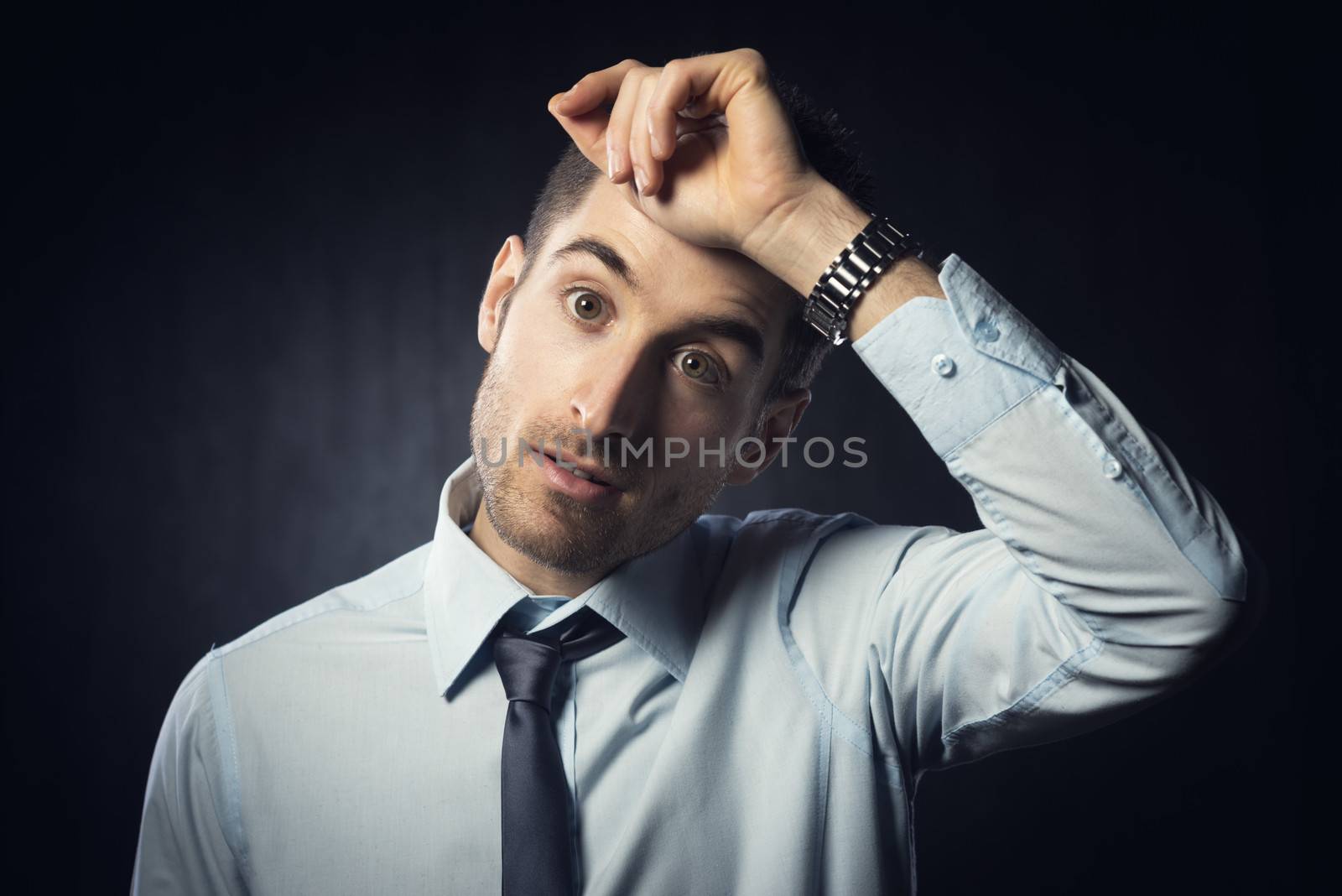 Exhausted office worker with hand on forehead and confused expression.