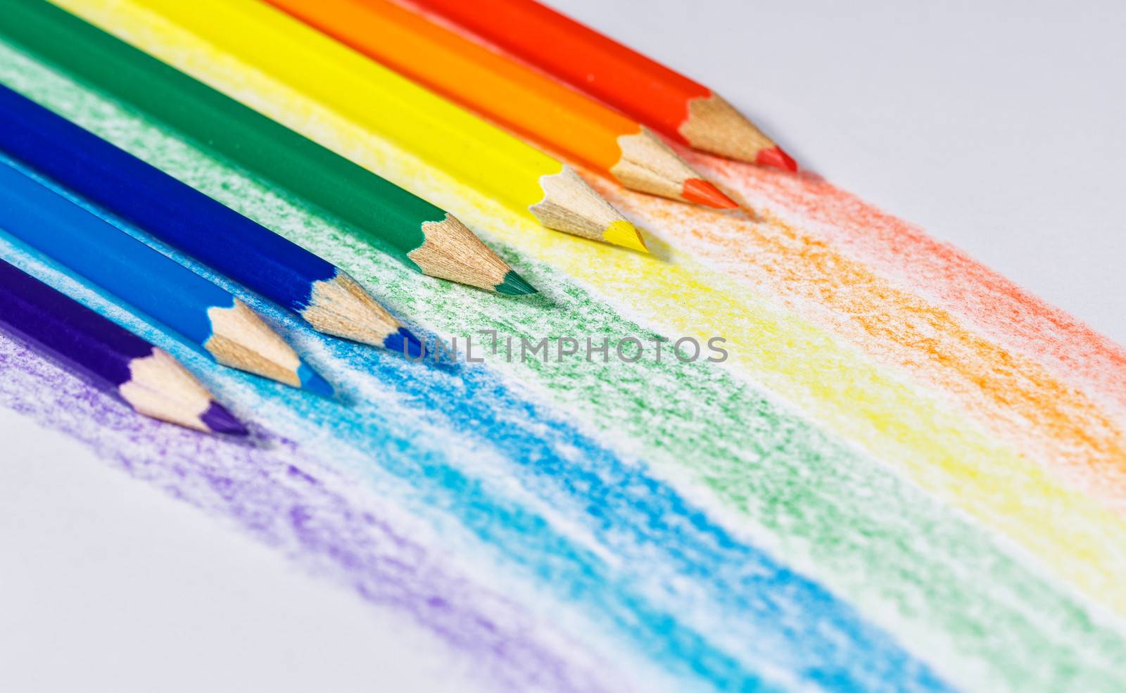 Rainbow colored pencils on textured paper shot close up