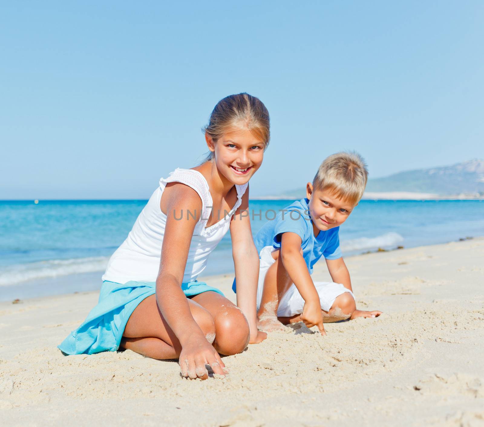 Two cute kids playing on tropical beach