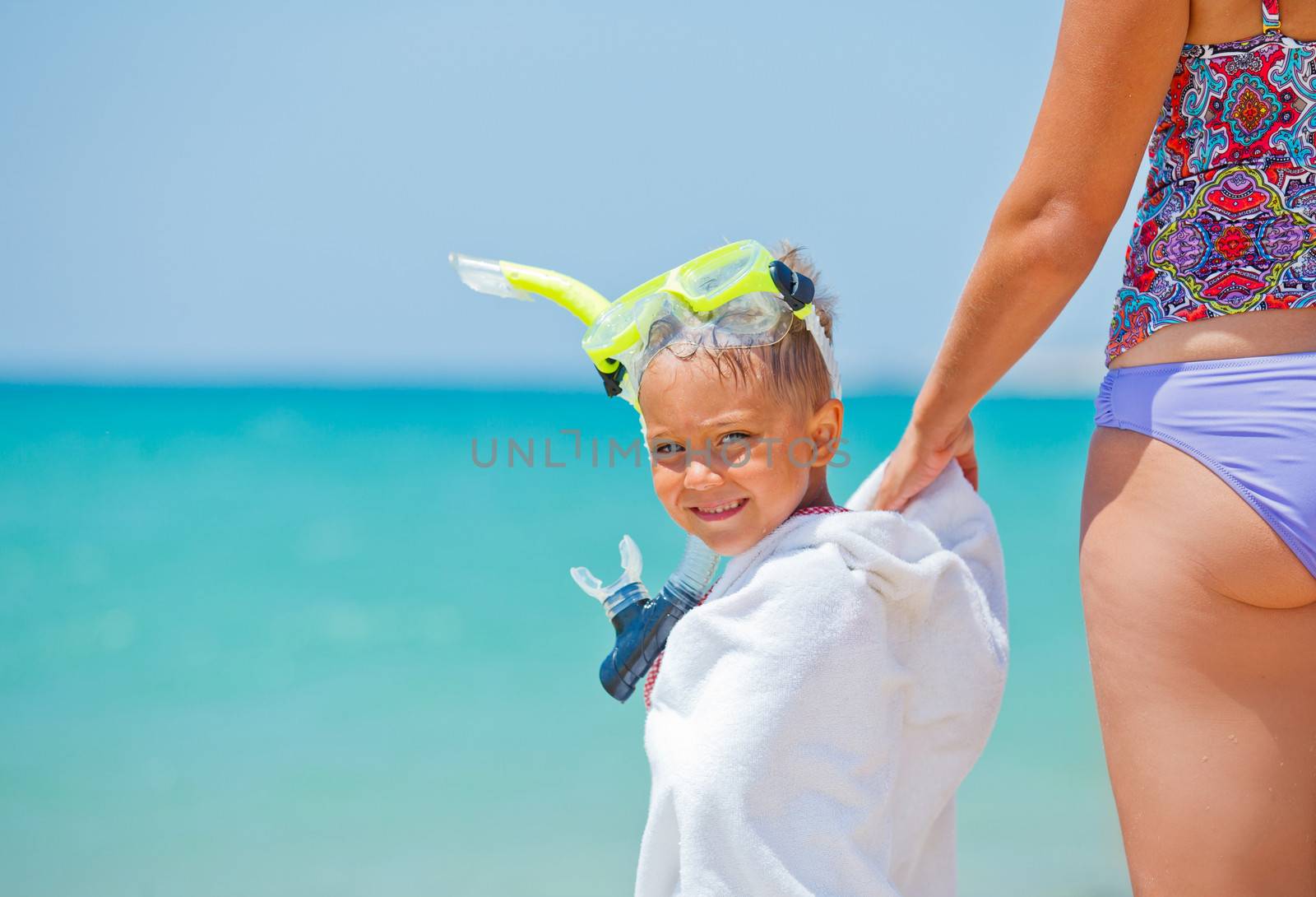 Summer vacation - Portrait of happy boy in face masks and snorkels, sea in background.