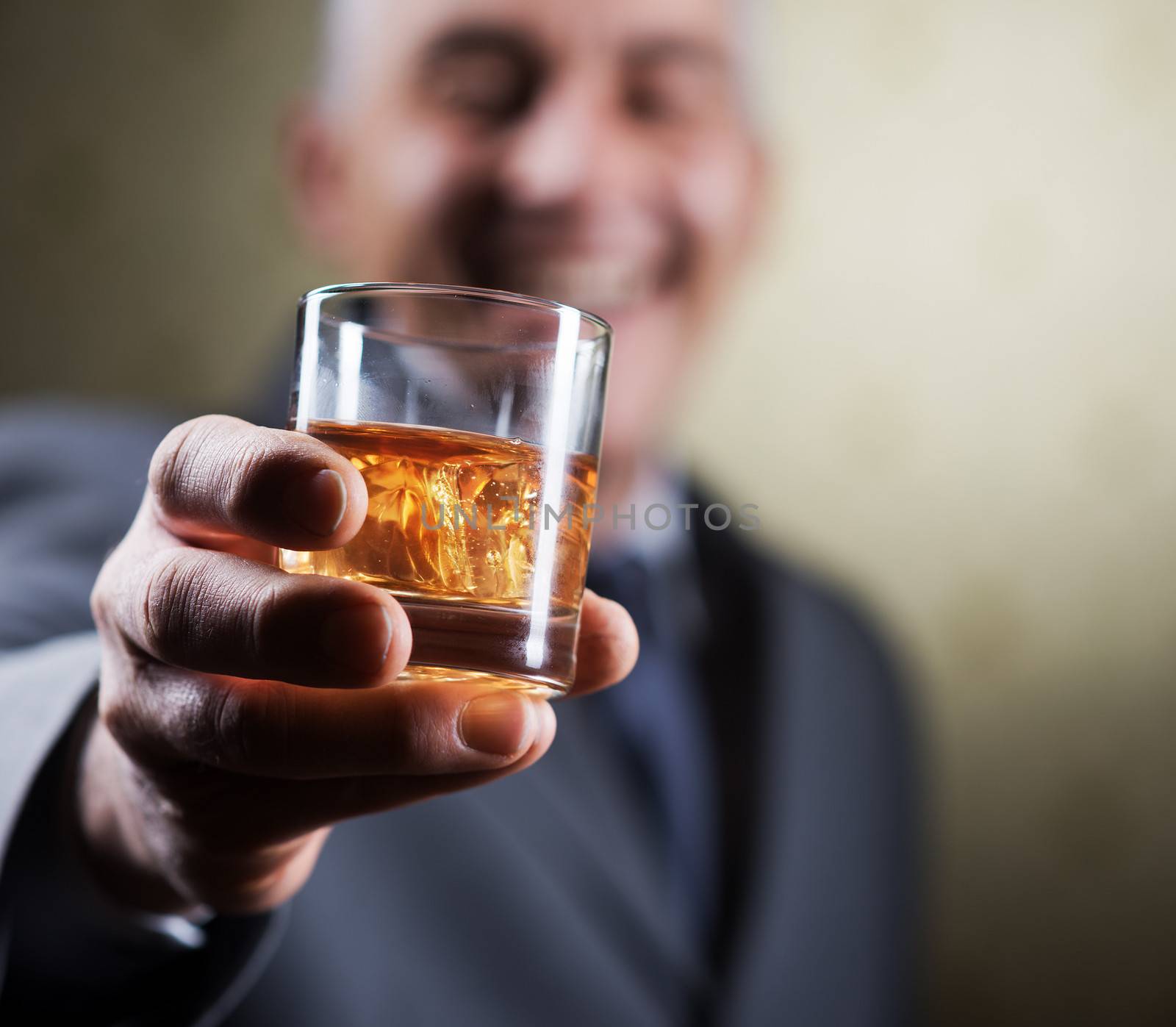 Businessman holding a glass of whisky, close up