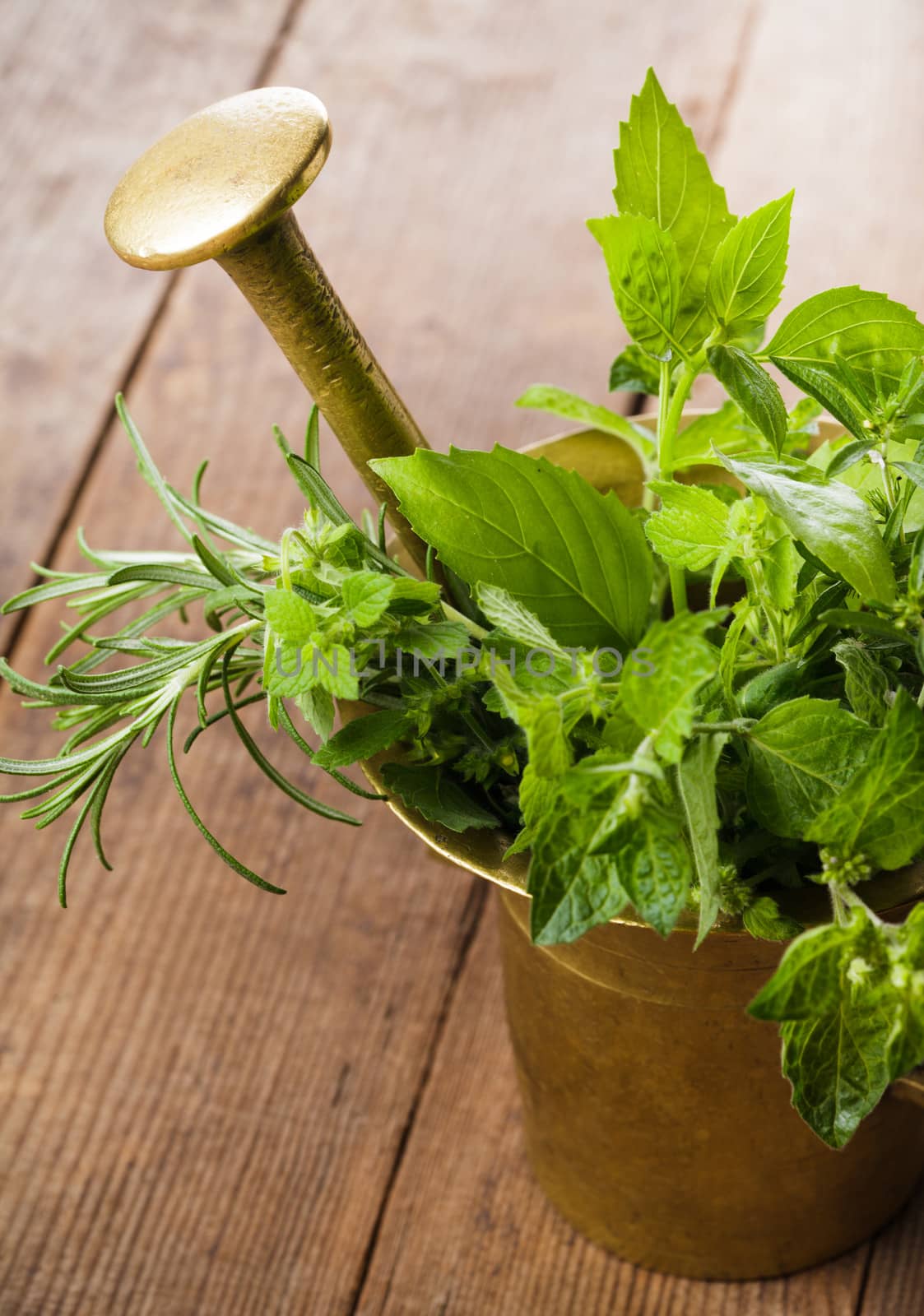 Fresh herbs in the copper mortar on the table