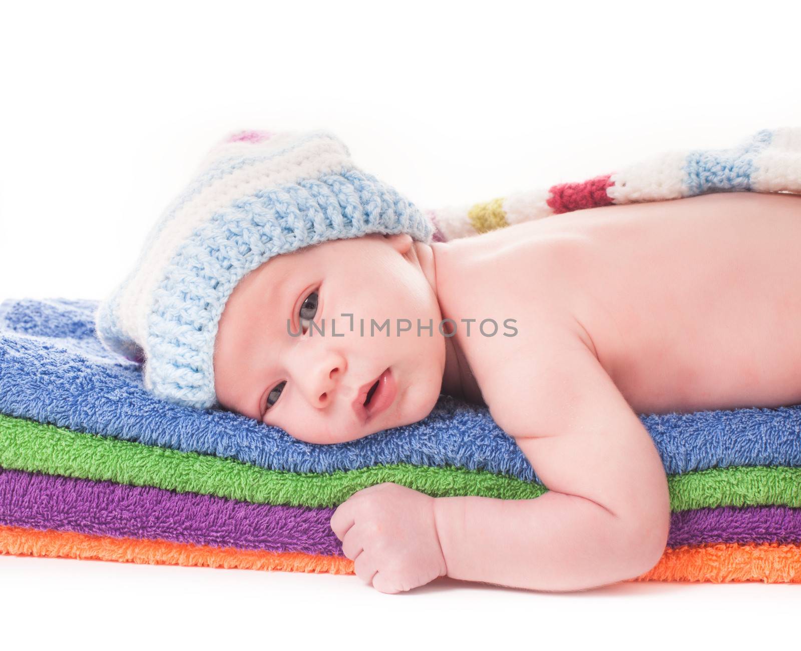 Baby on the color 
towels in crochet hat close up