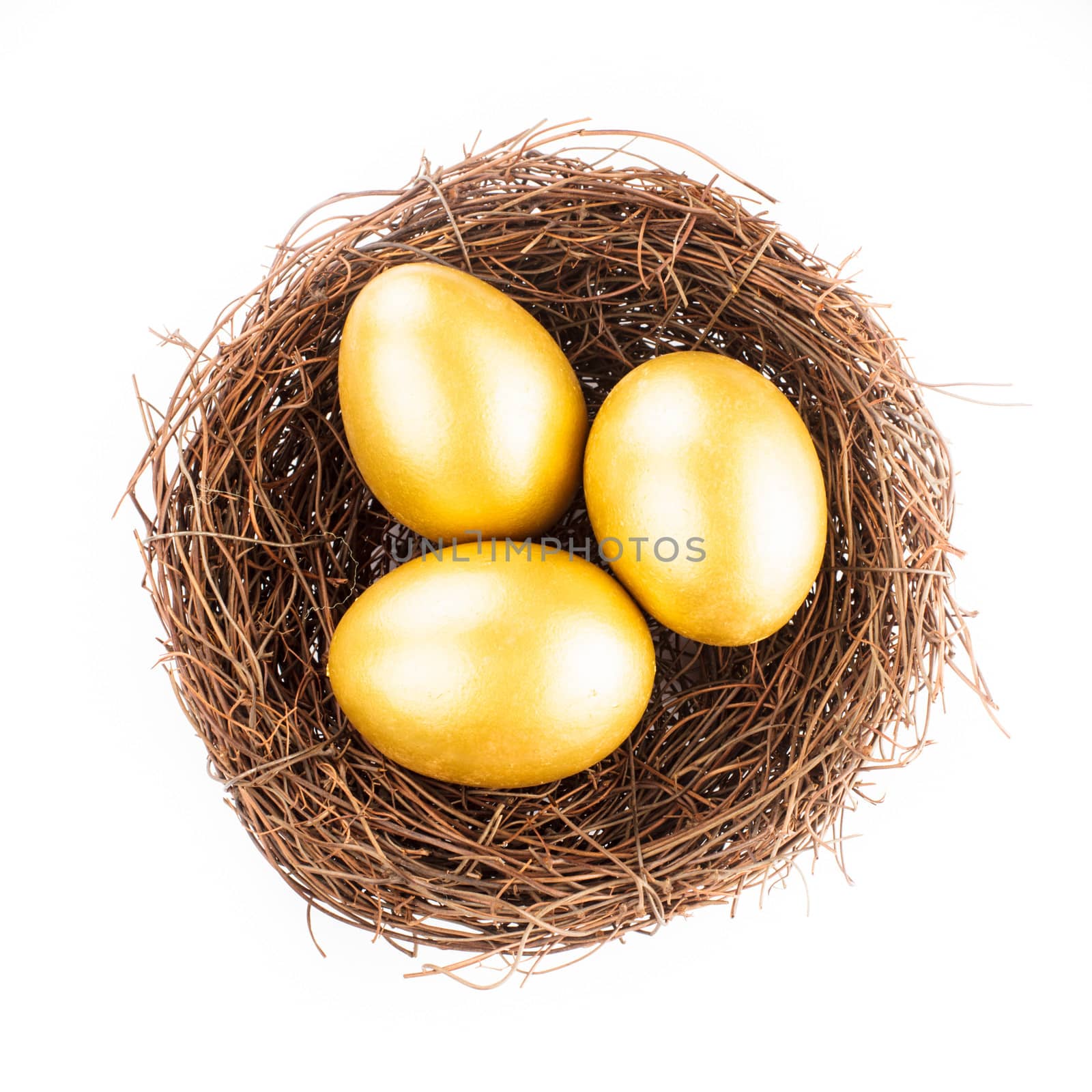 Three golden eggs in the nest isolated on white