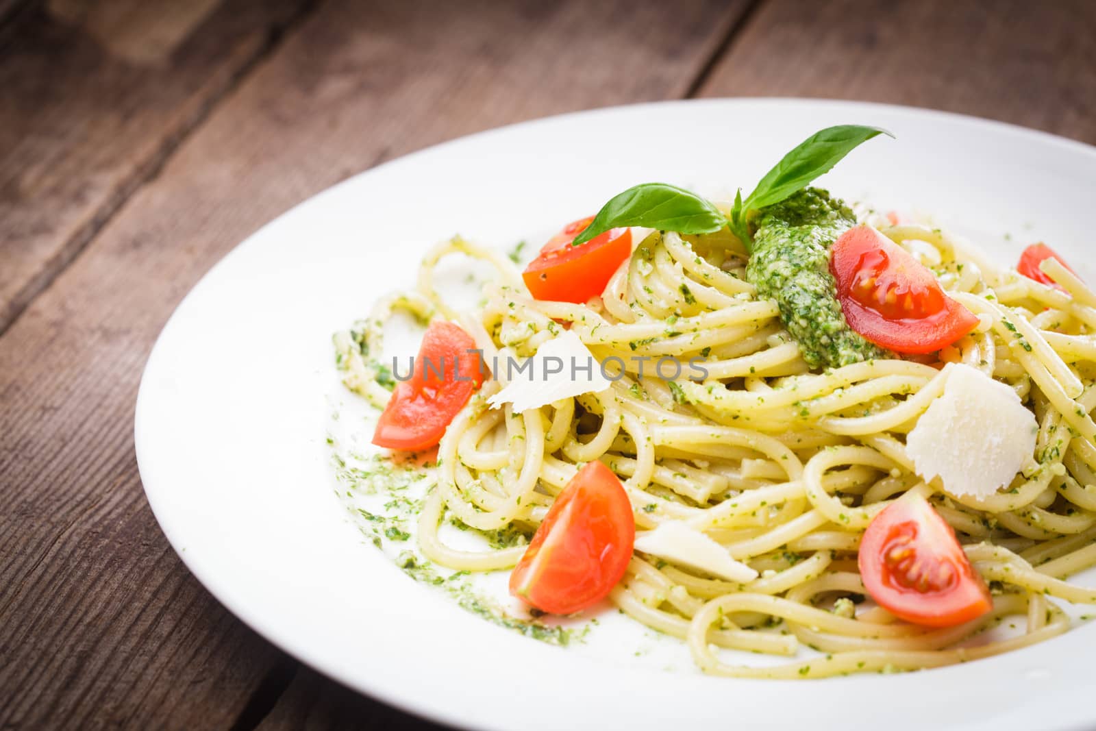 Spaghetti with green pesto, parmesan and cherry tomatoes