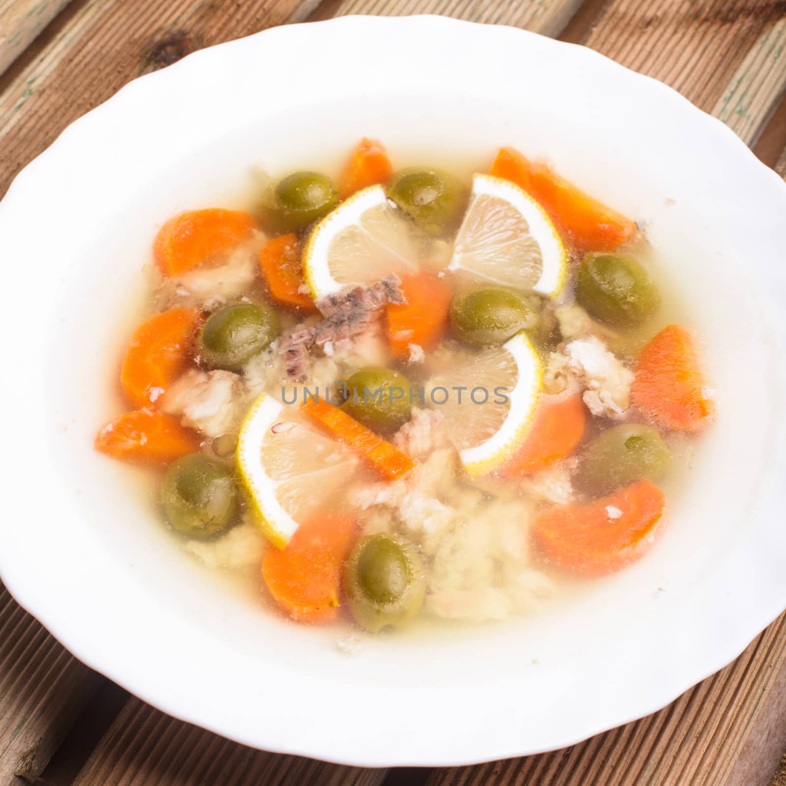 Sturgeon with lemon and carrot slices and green olives in aspic