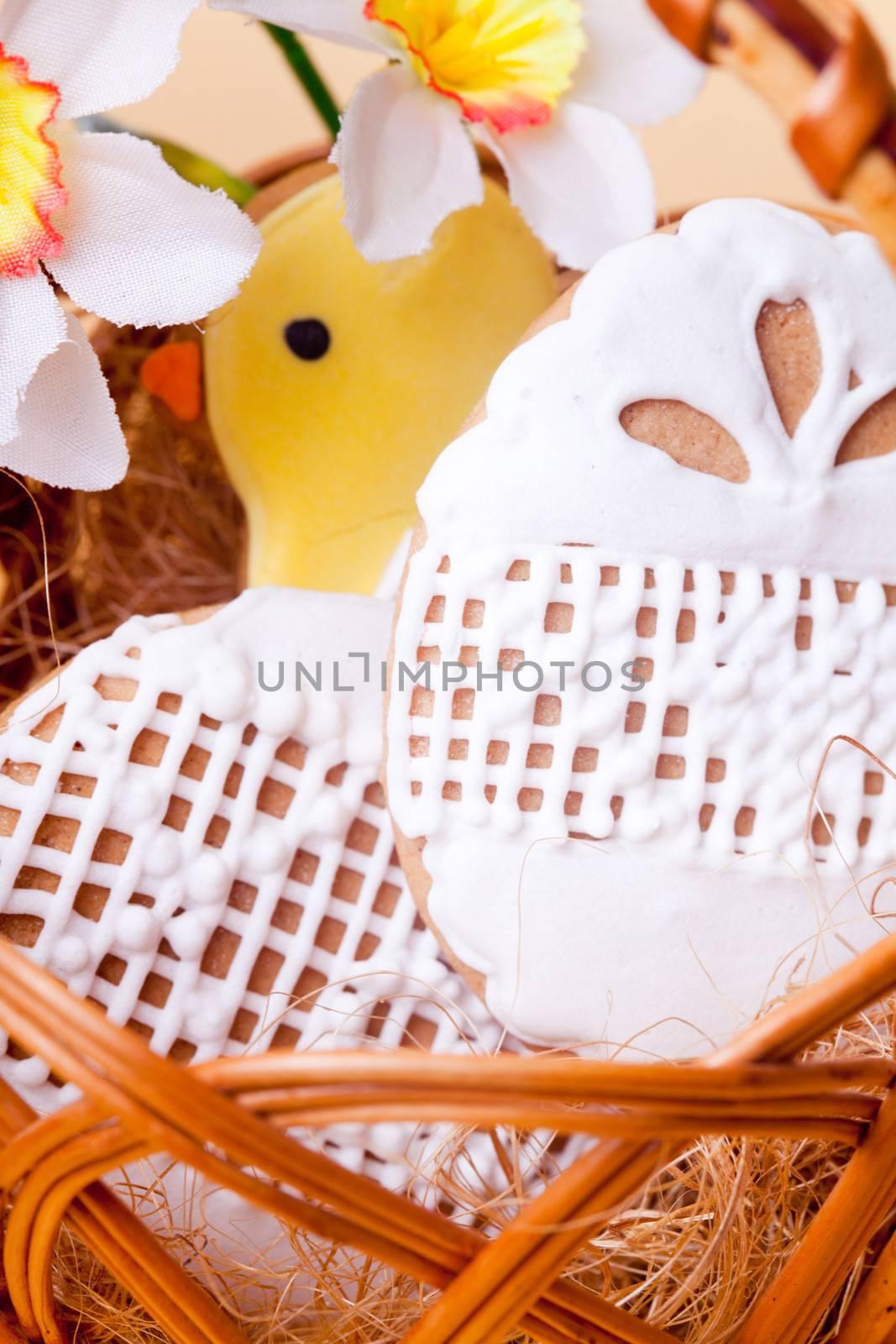 Easter cookies in basket over yellow background. Easter decor