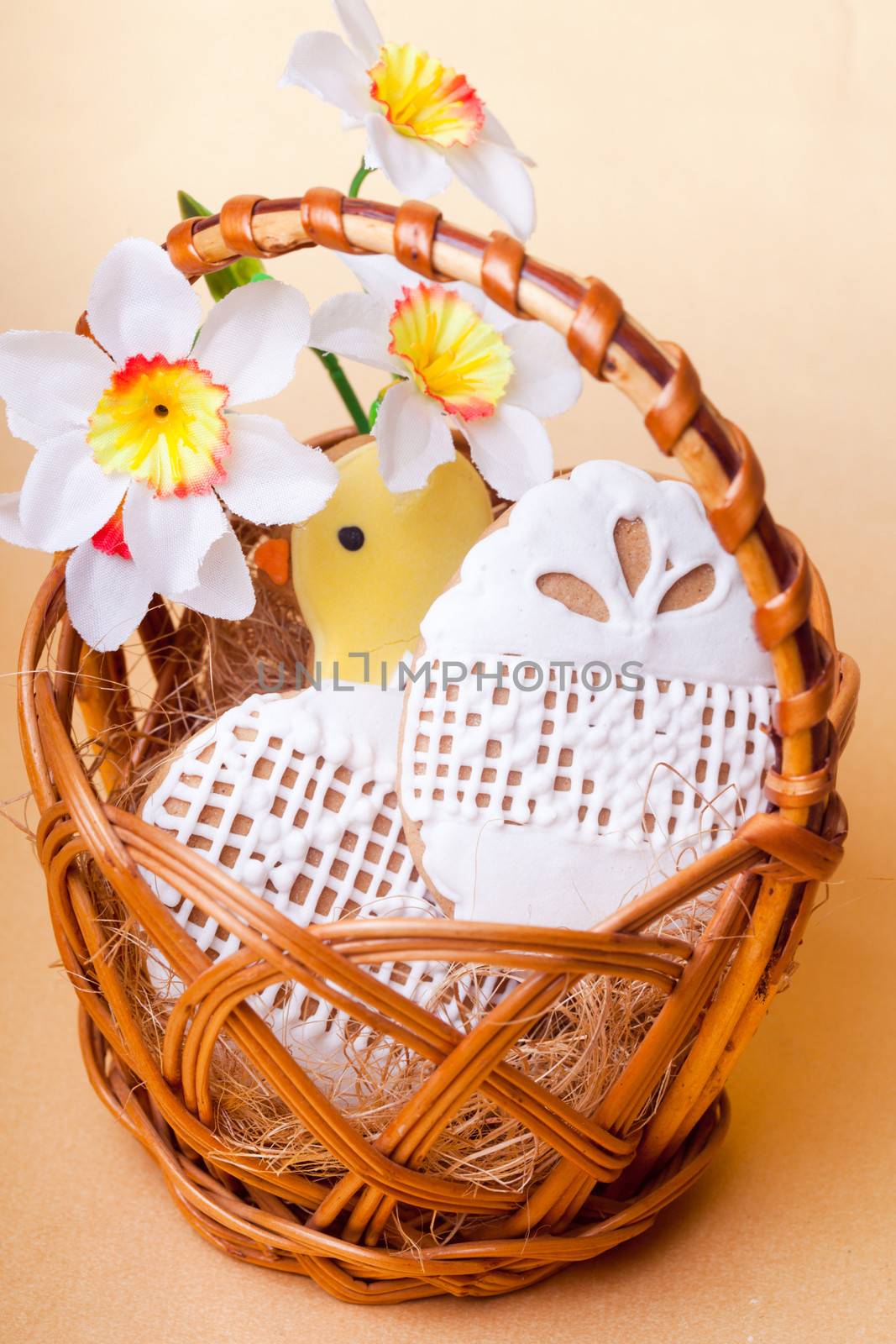 Easter cookies in basket over yellow background. Easter decor